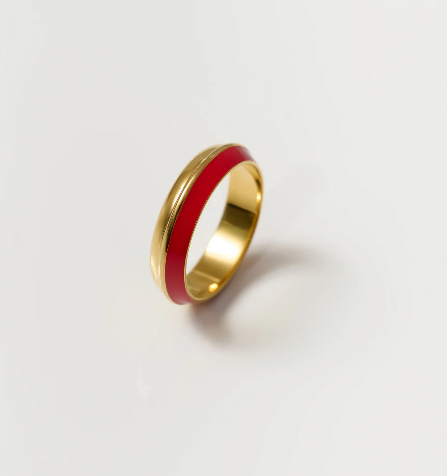 Ravya Ring in warm gold with rich red enamel band, elegant and understated design.