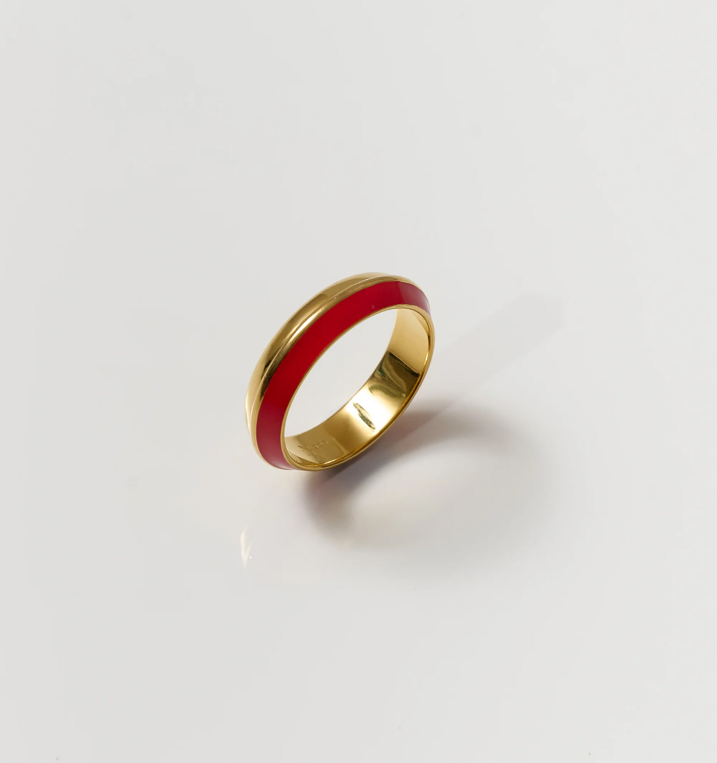 Ravya Ring gold band with rich red enamel detail on white background
