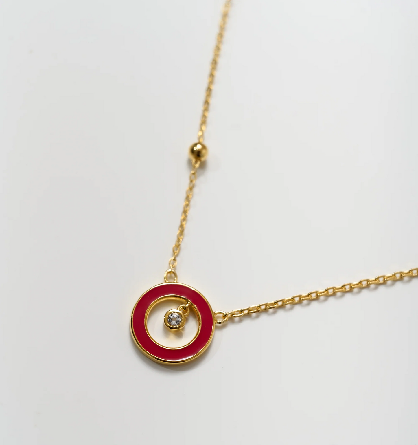 Trika Necklace gold chain with red circle pendant and central crystal sparkle