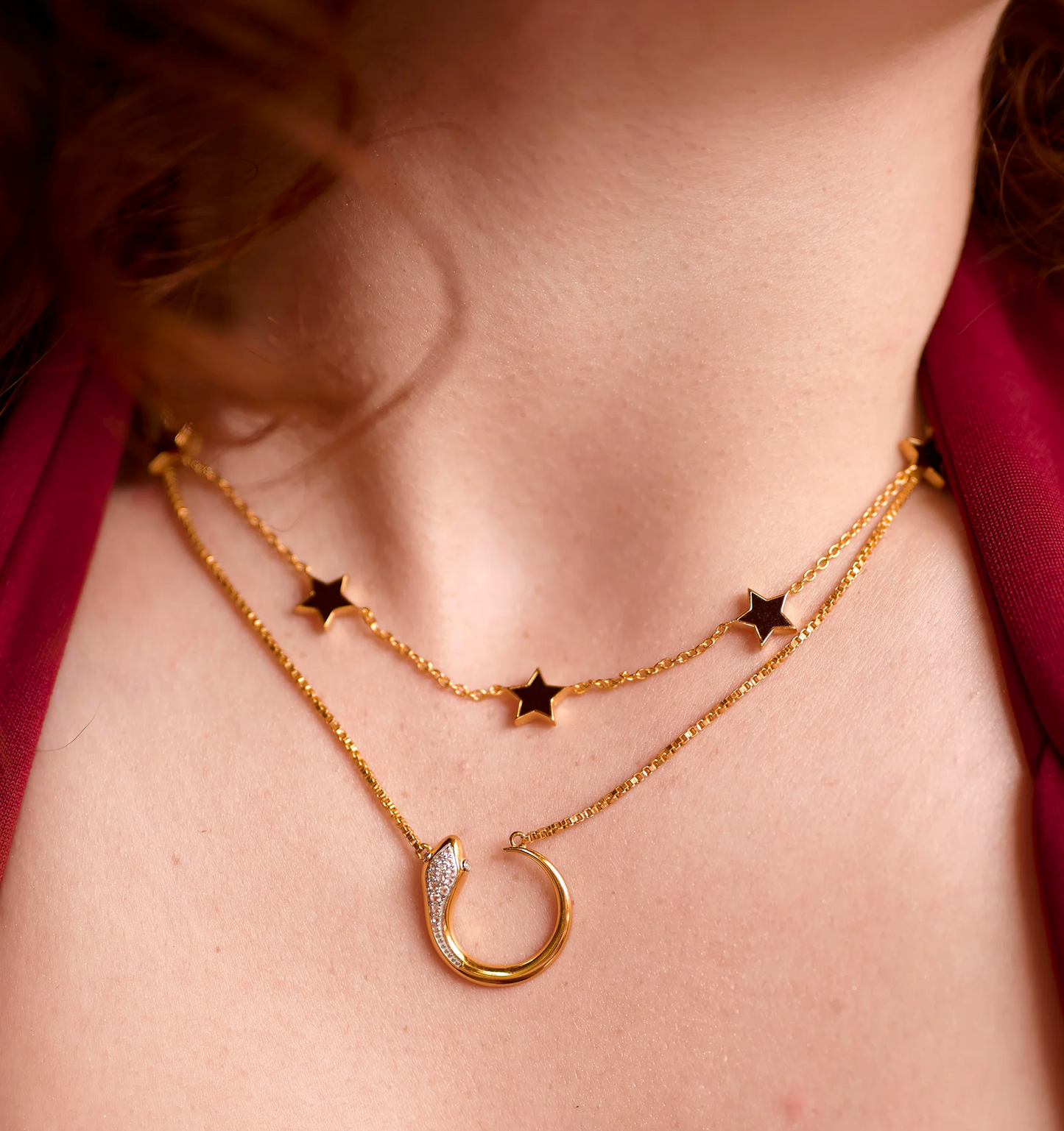 Elegant Noctra Necklace with gold chains featuring black stars and a crescent moon pendant on a woman's neck
