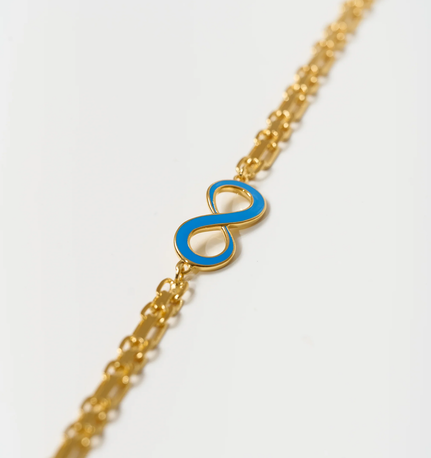 Avaanta Necklace with turquoise enamel infinity symbol on gold chain representing endless presence