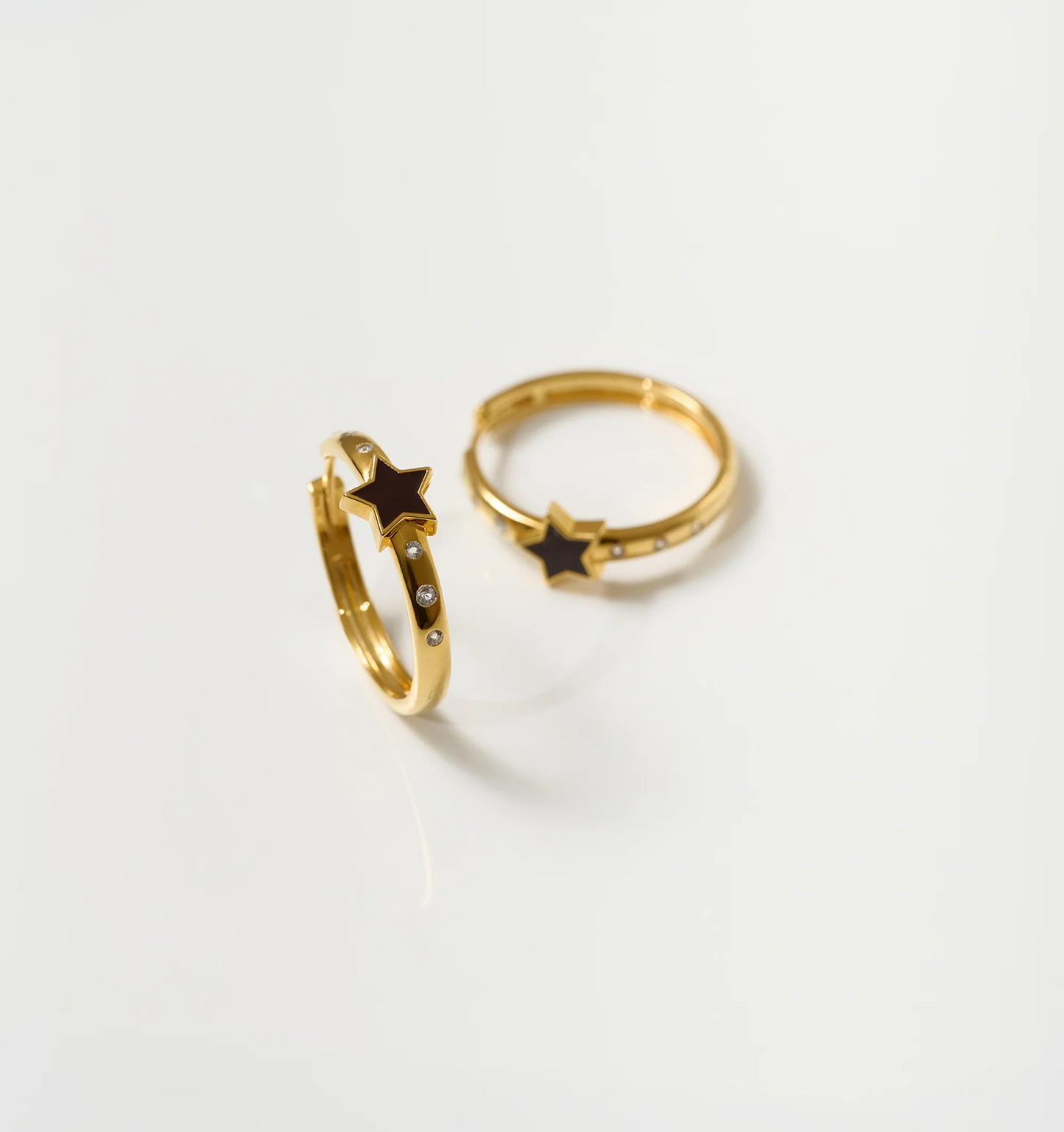 Tara Nova Hoop gold earrings with star design and white topaz stones on white background