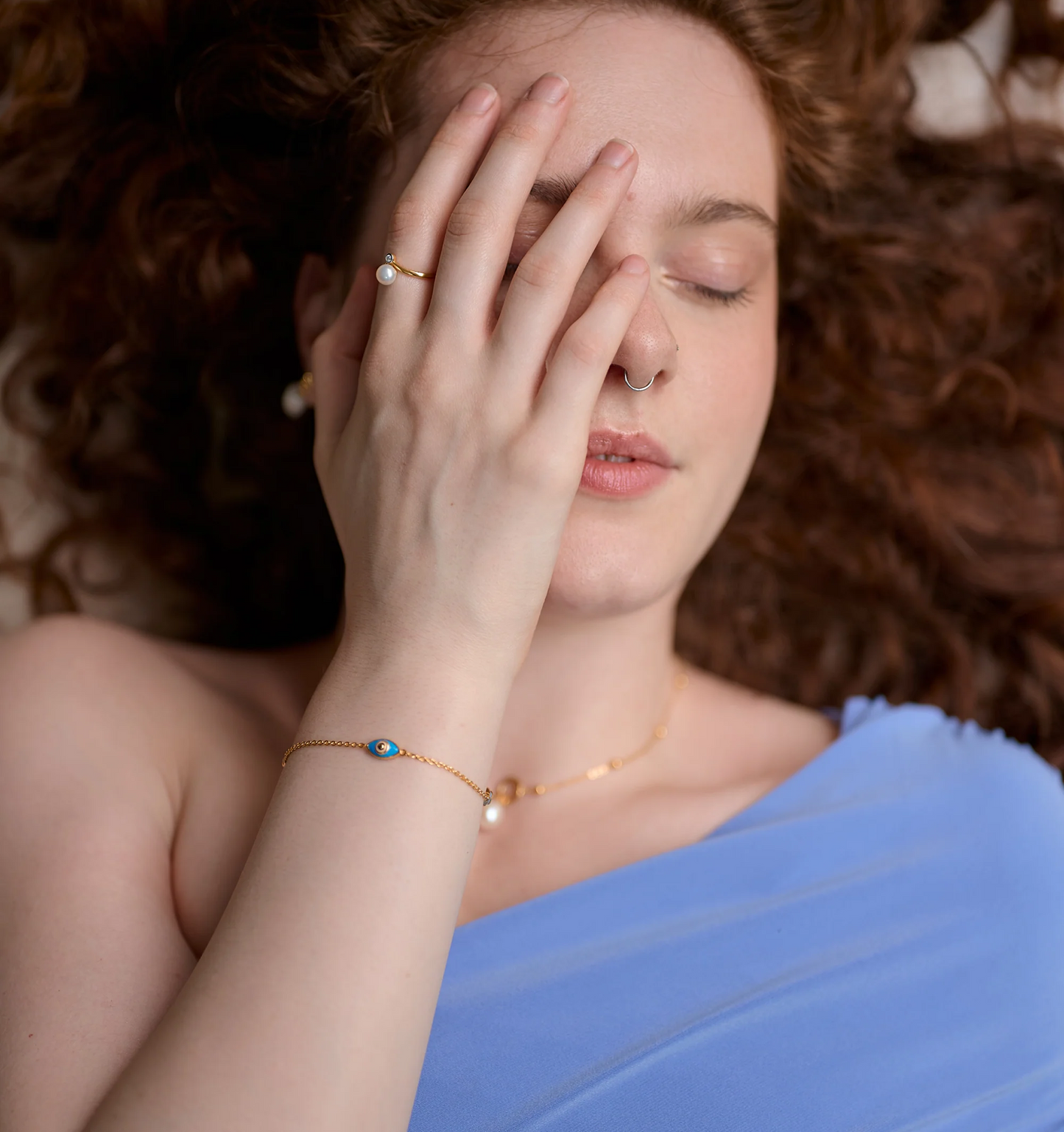 Woman wearing Dhrish Bracelet with turquoise enamel on wrist and blue dress