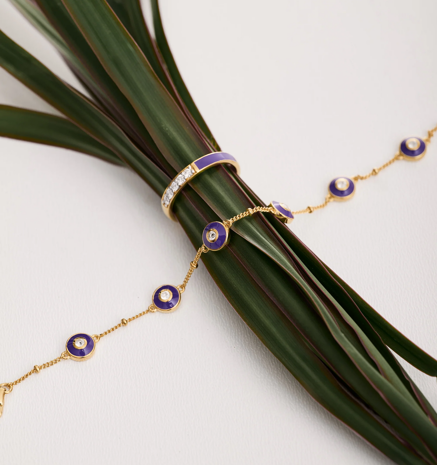Pancha Ring gold band with purple arc and diamonds on green leaves with matching gold and purple bracelet chain