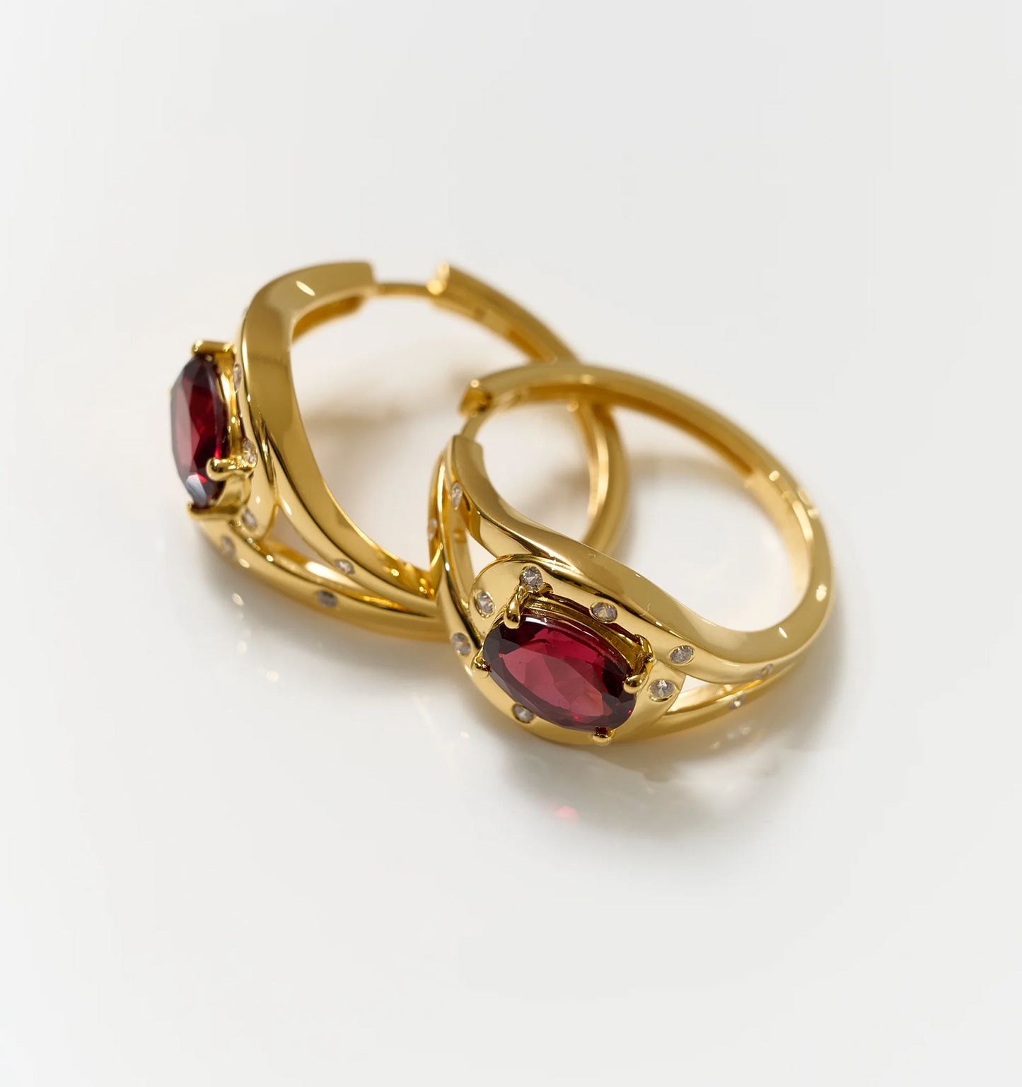 Elegant gold Ruvya Hoops featuring garnet and white zircon gemstones