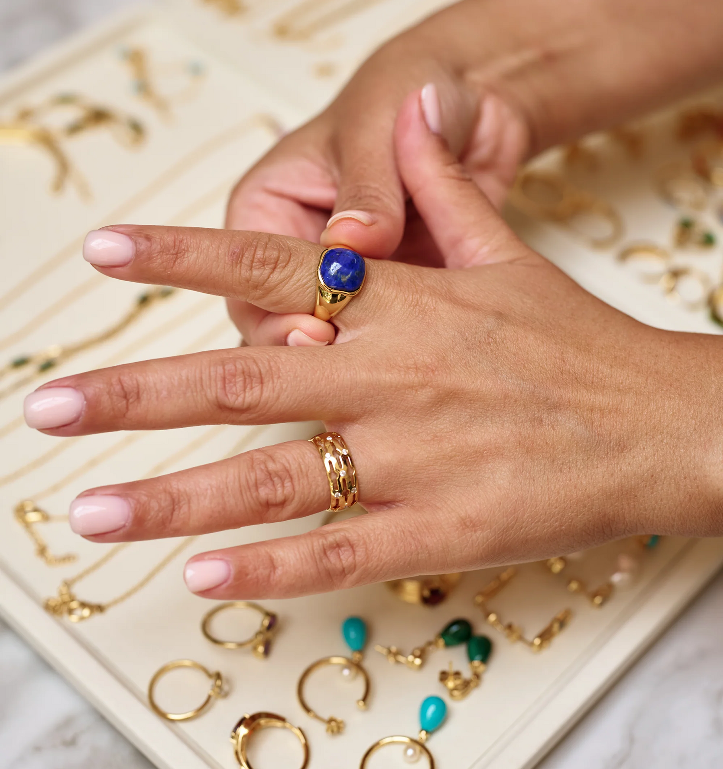 Neelaya Ring with bold blue lapis stone on hand over jewelry display tray