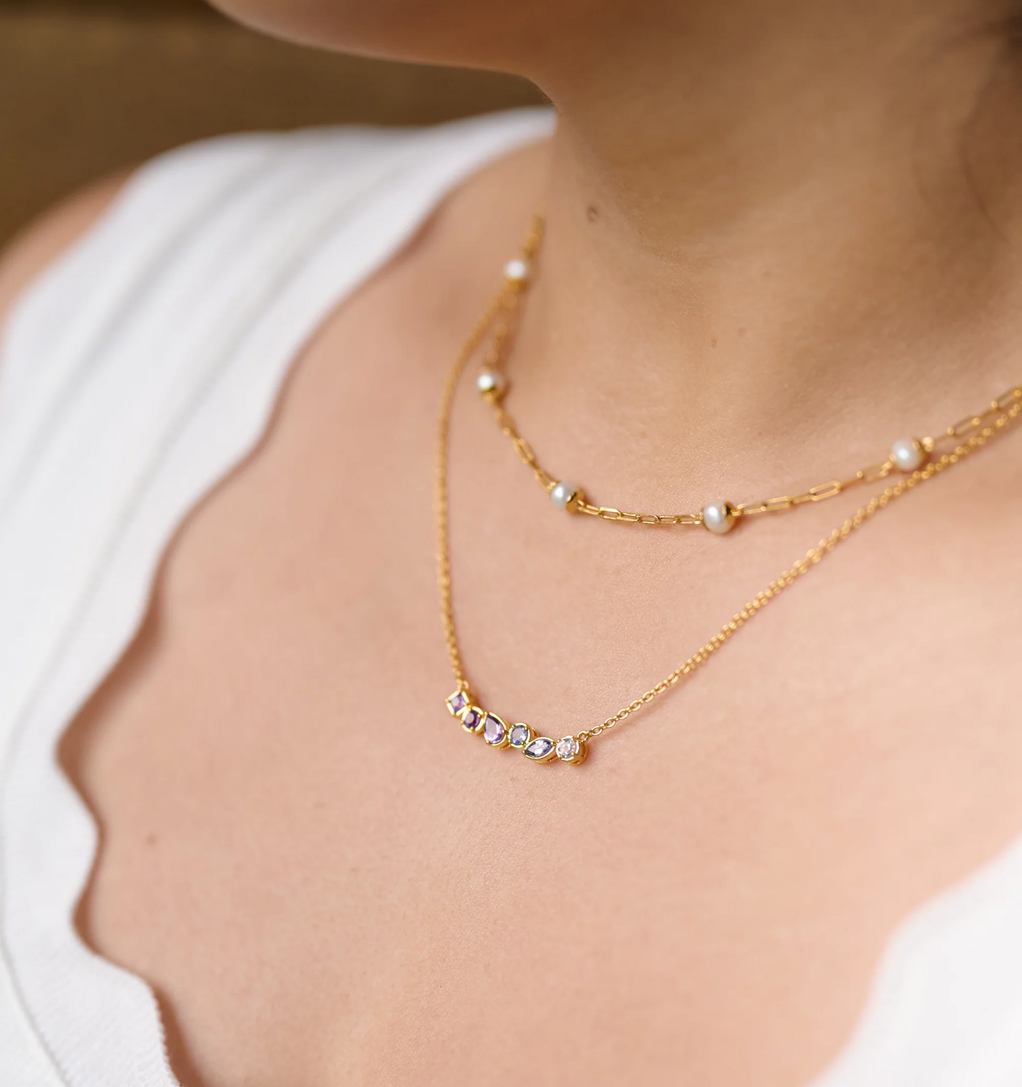 Raag Necklace with amethyst, tanzanite, and topaz in gold setting on a woman's neck