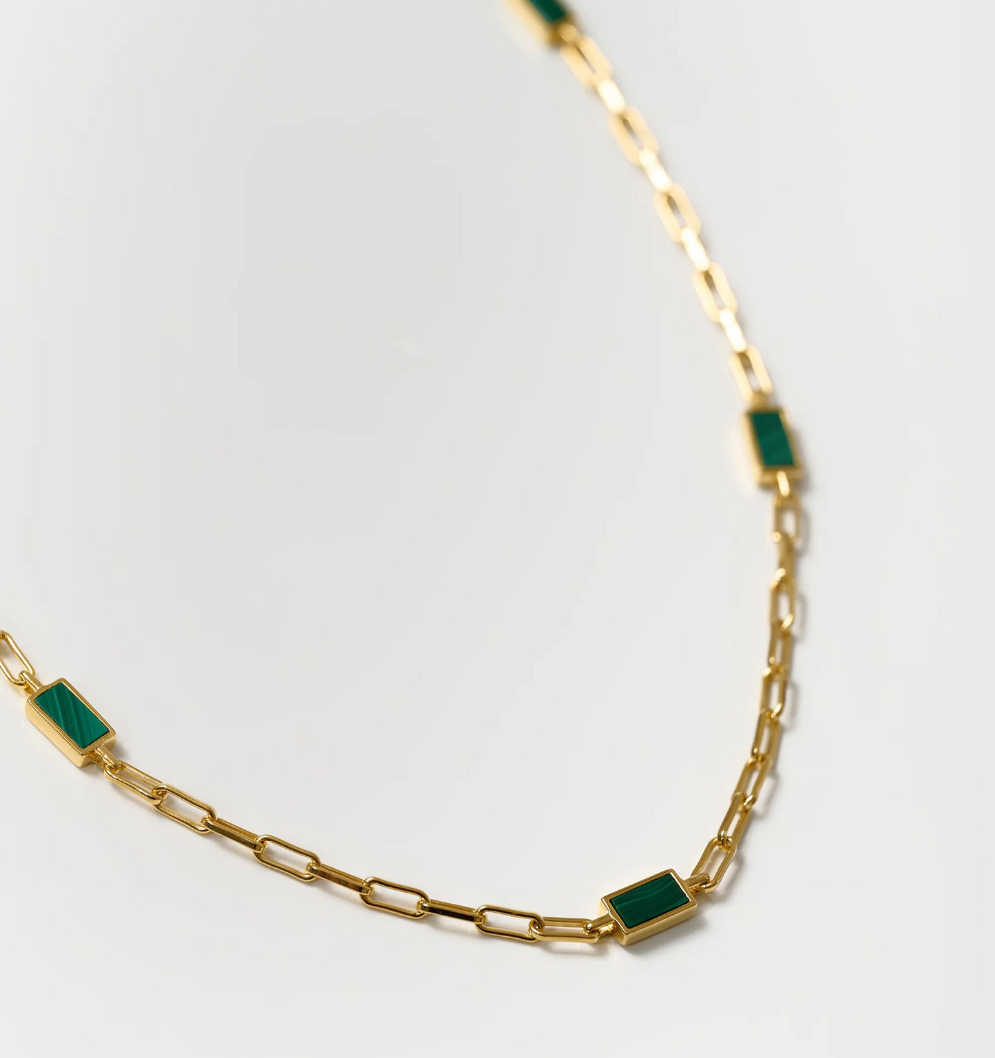 Tarang Necklace with seven green Malachite stones set in a gold chain for heart chakra balance and protection.