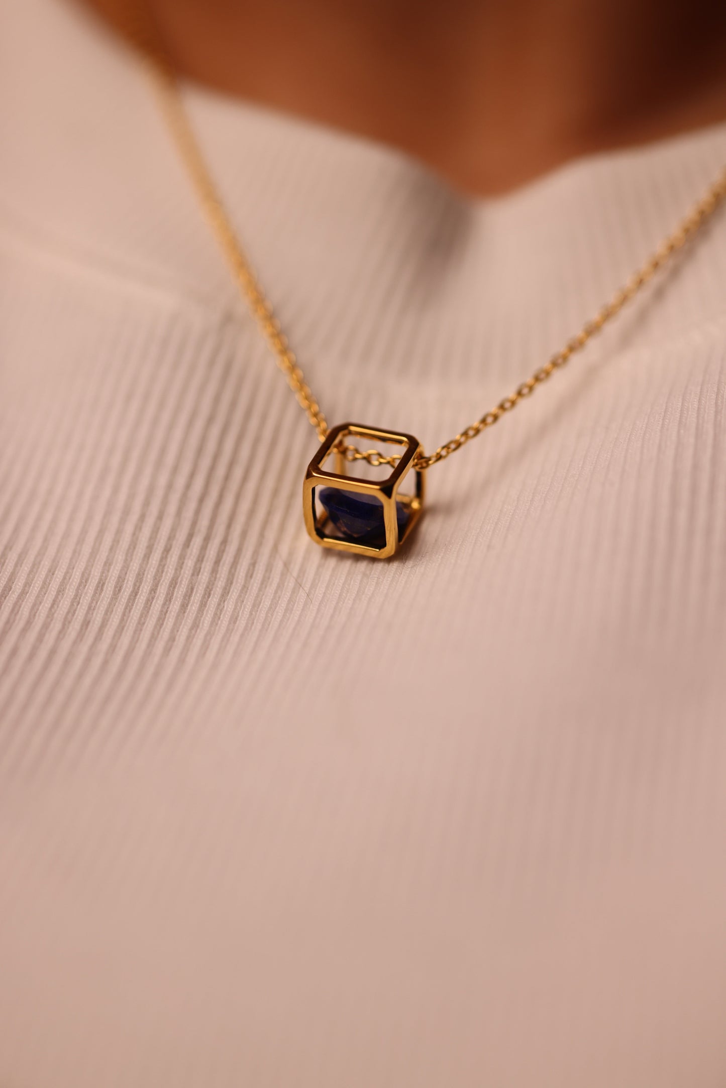 Kosha Necklace with round blue Lapis Lazuli stone suspended in gold square frame