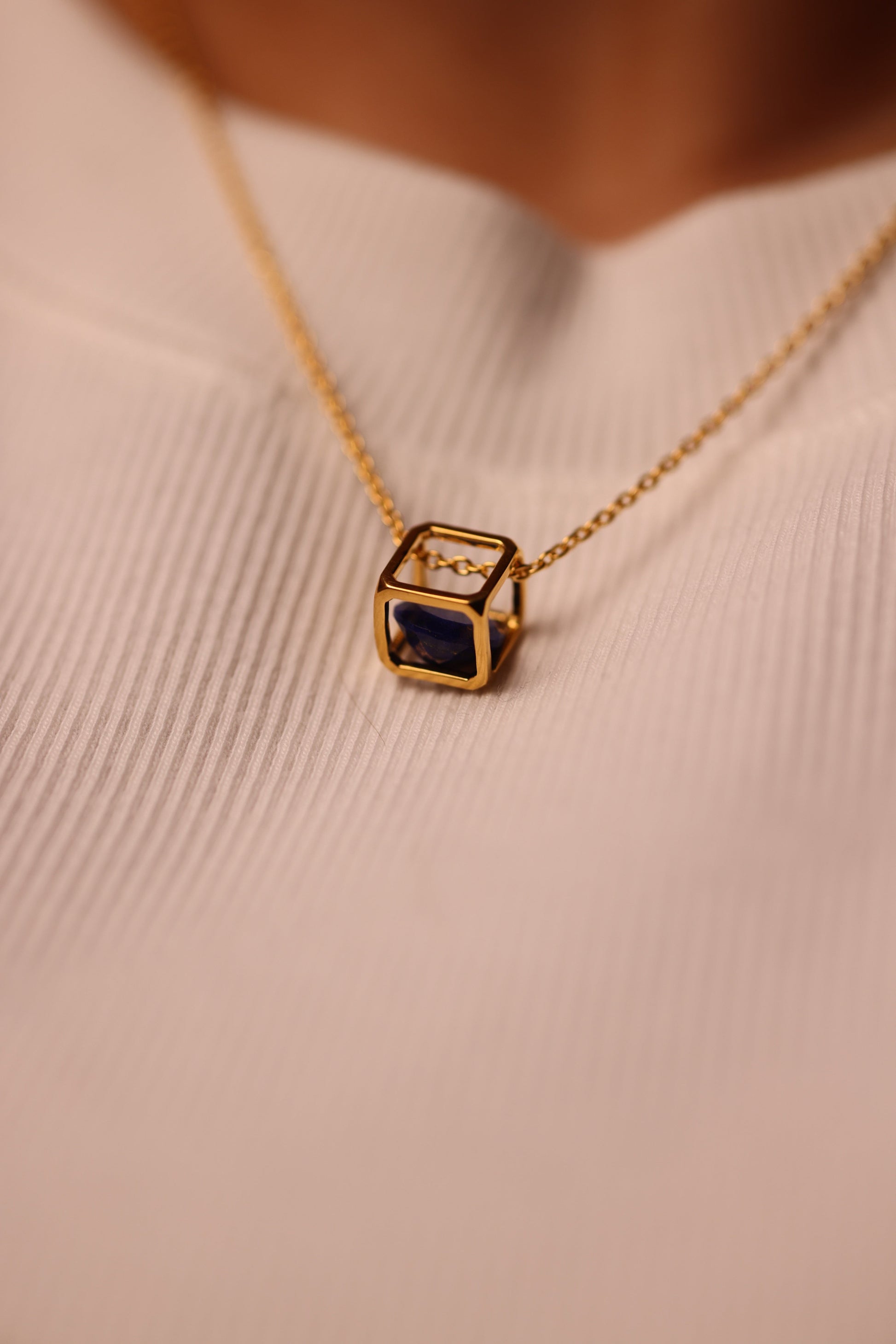 Kosha Necklace with round blue Lapis Lazuli stone suspended in gold square frame