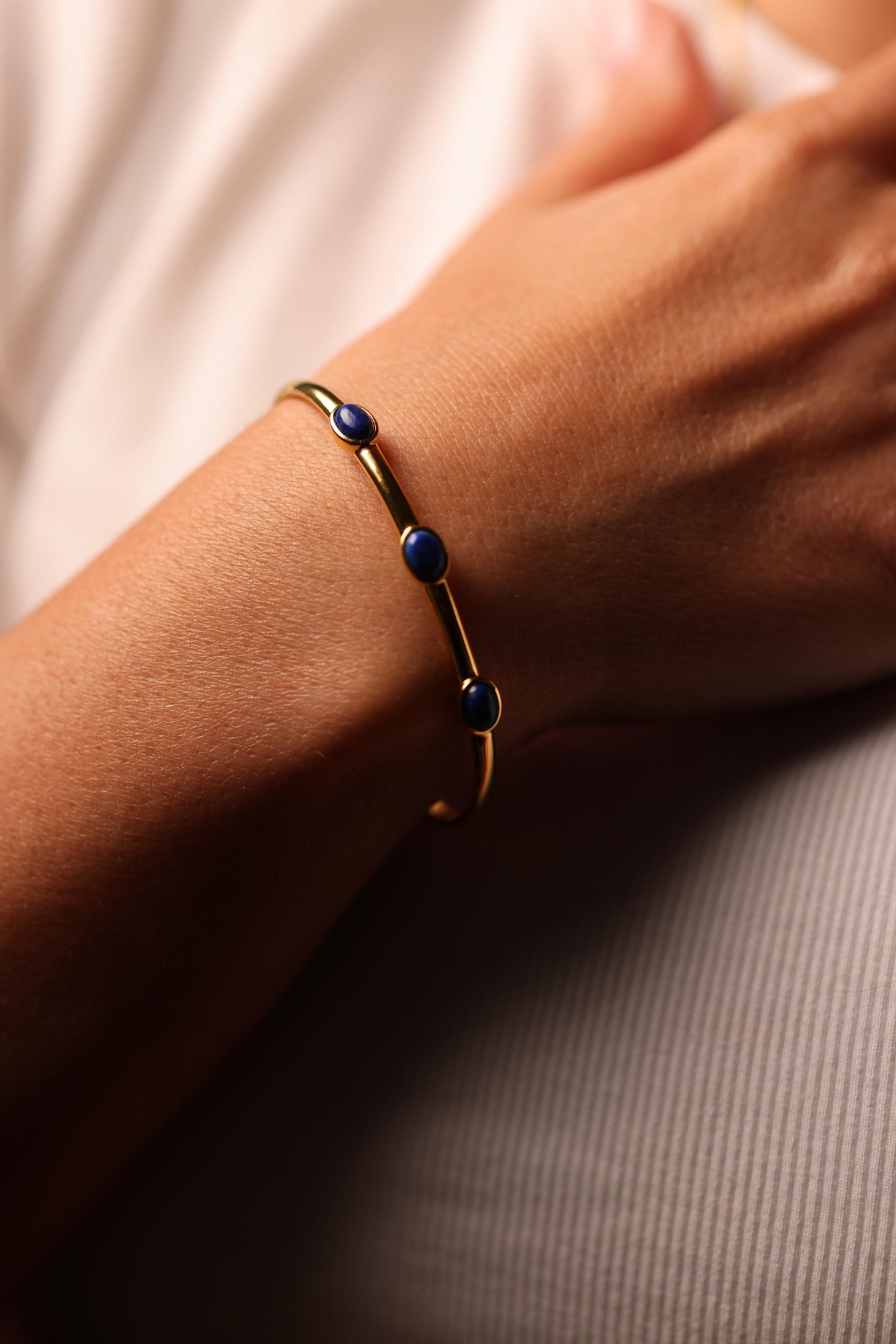 Trivena Cuff with three deep blue Lapis Lazuli cabochon stones in a minimal gold framework.