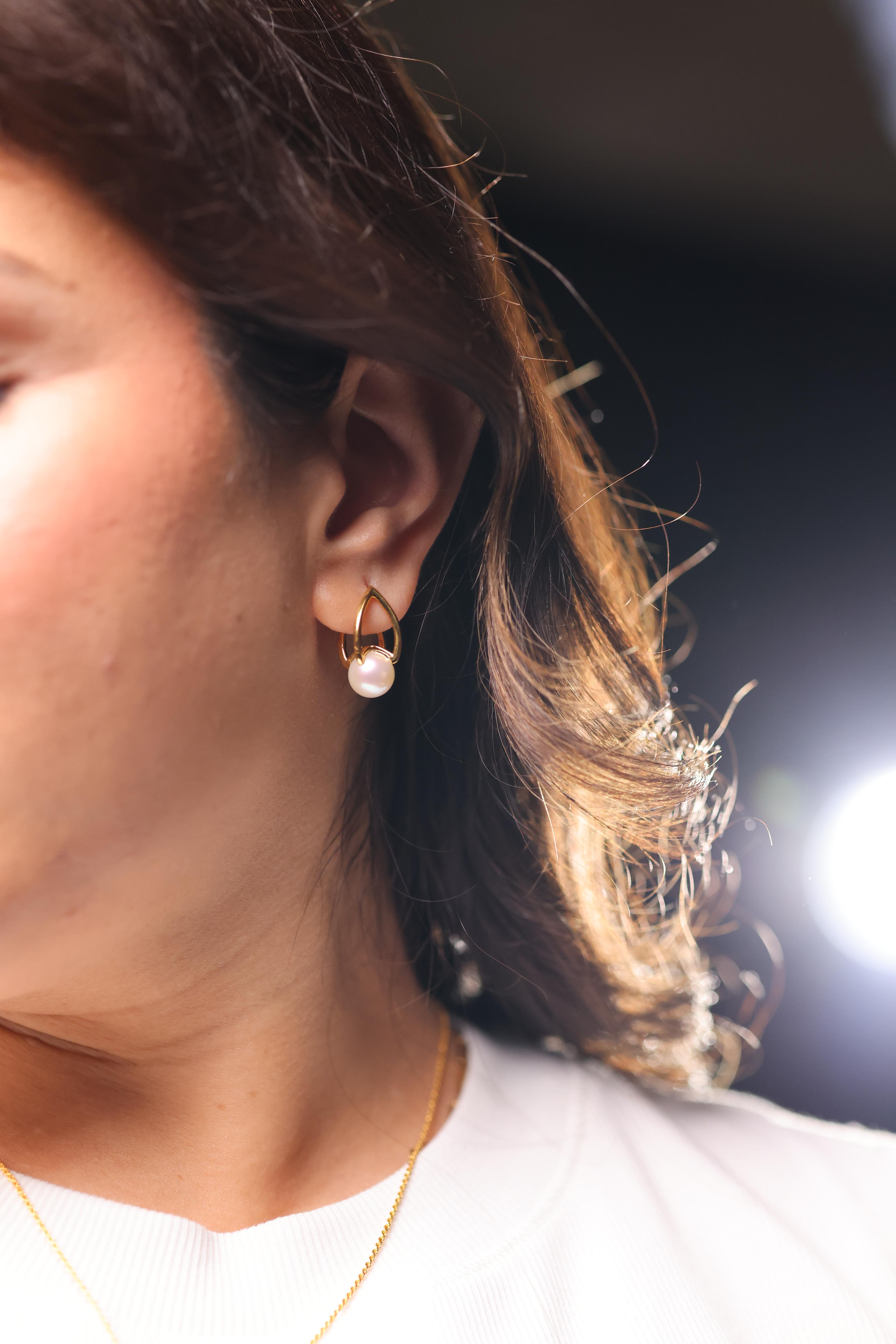 Shanta Earring with luminous pearl in open gold sculptural design, modern and refined.