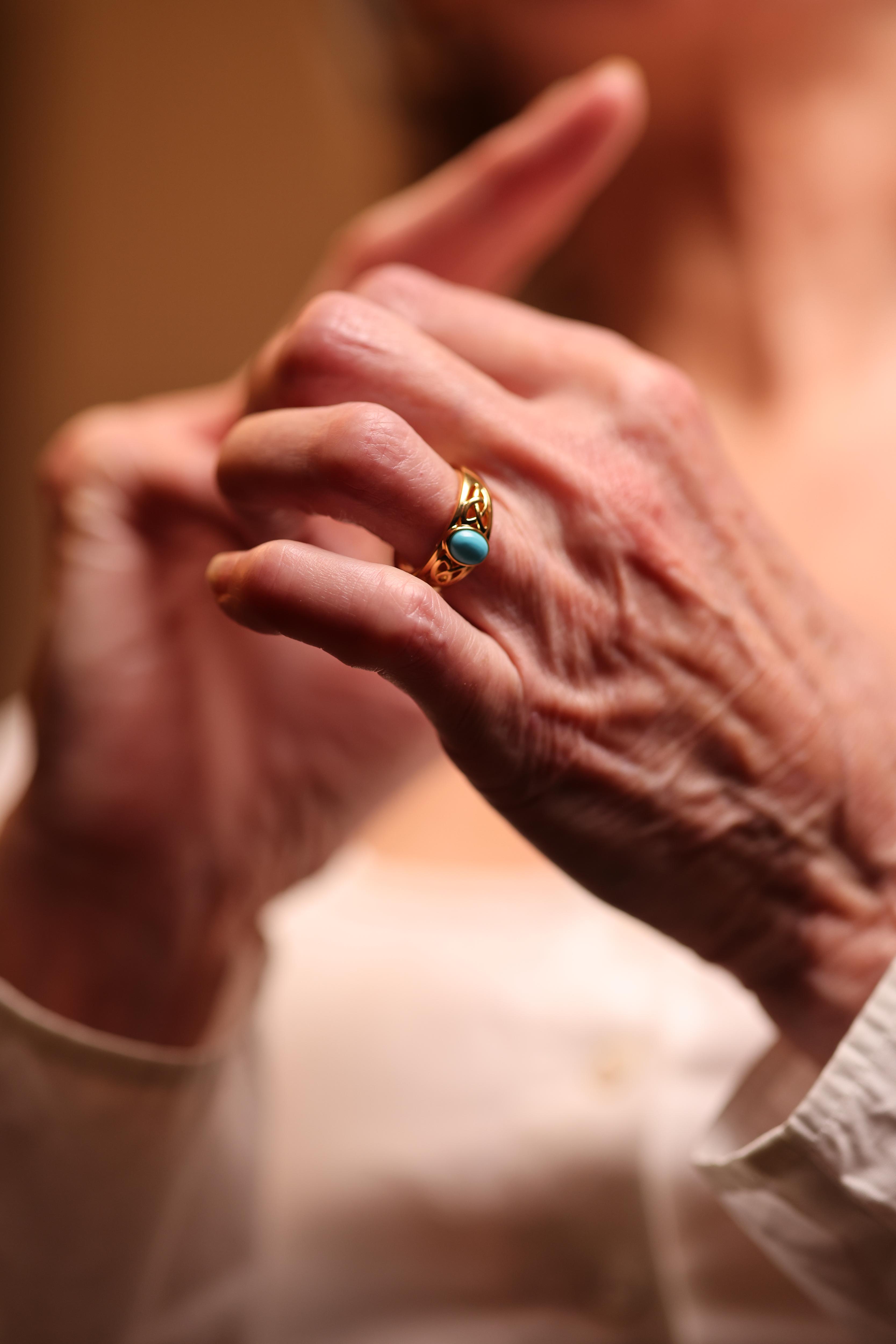 Neera Ring with smooth oval turquoise on openwork gold band, symbolizing calm and elegance