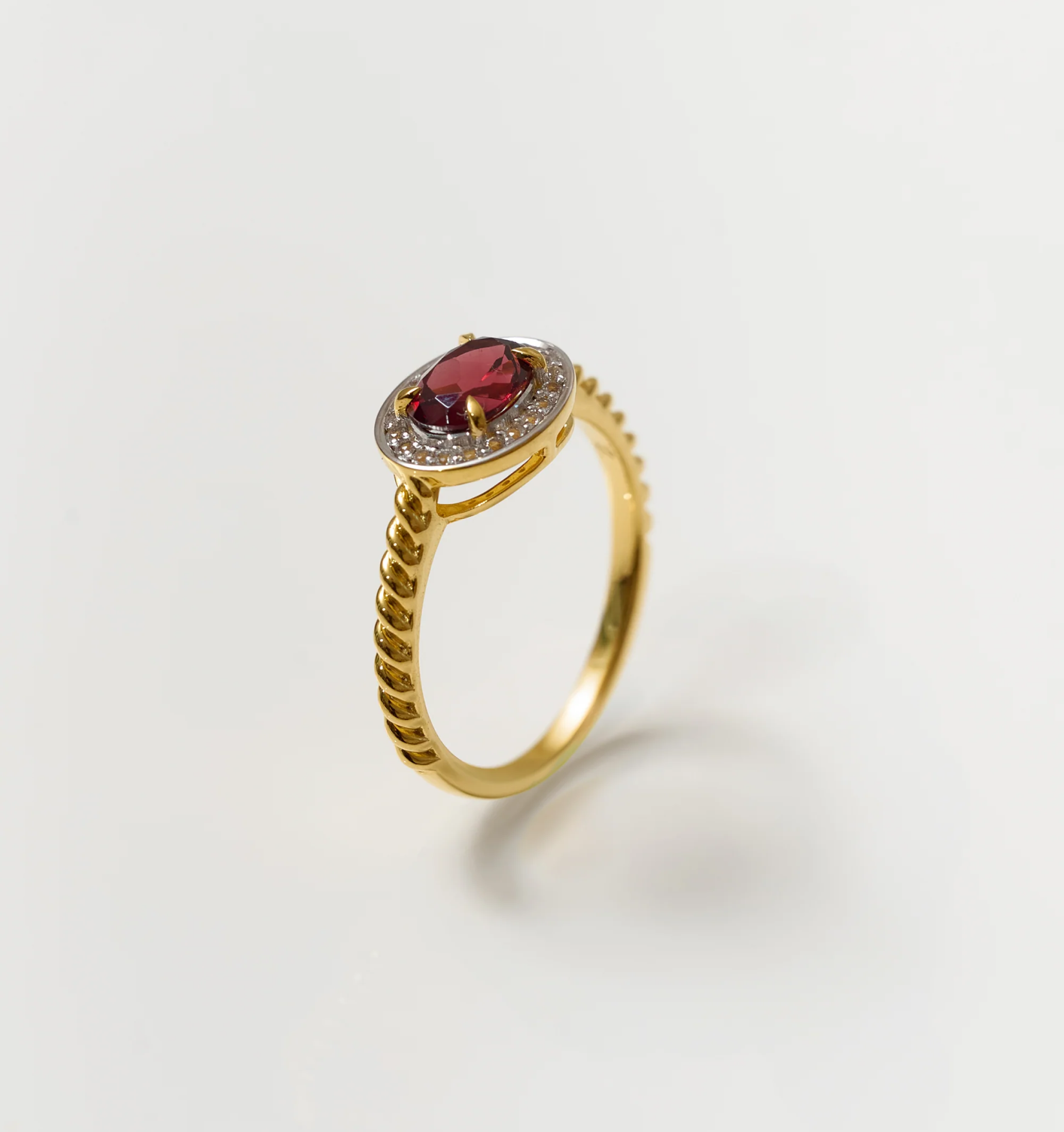 Agira Ring with garnet center stone and white topaz halo on gold band