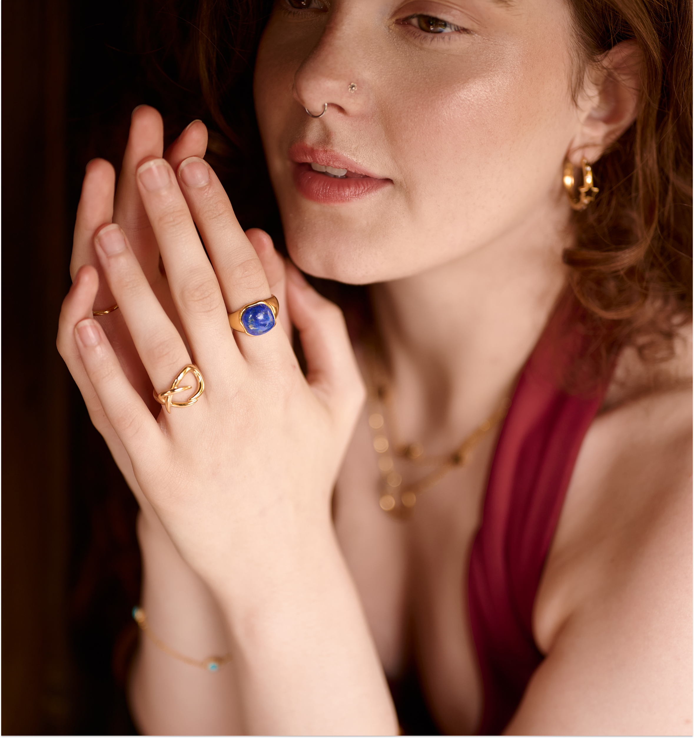 Close-up of a woman wearing the gold Karvat Ring with curves on her finger, showcasing its elegant and sculpted design