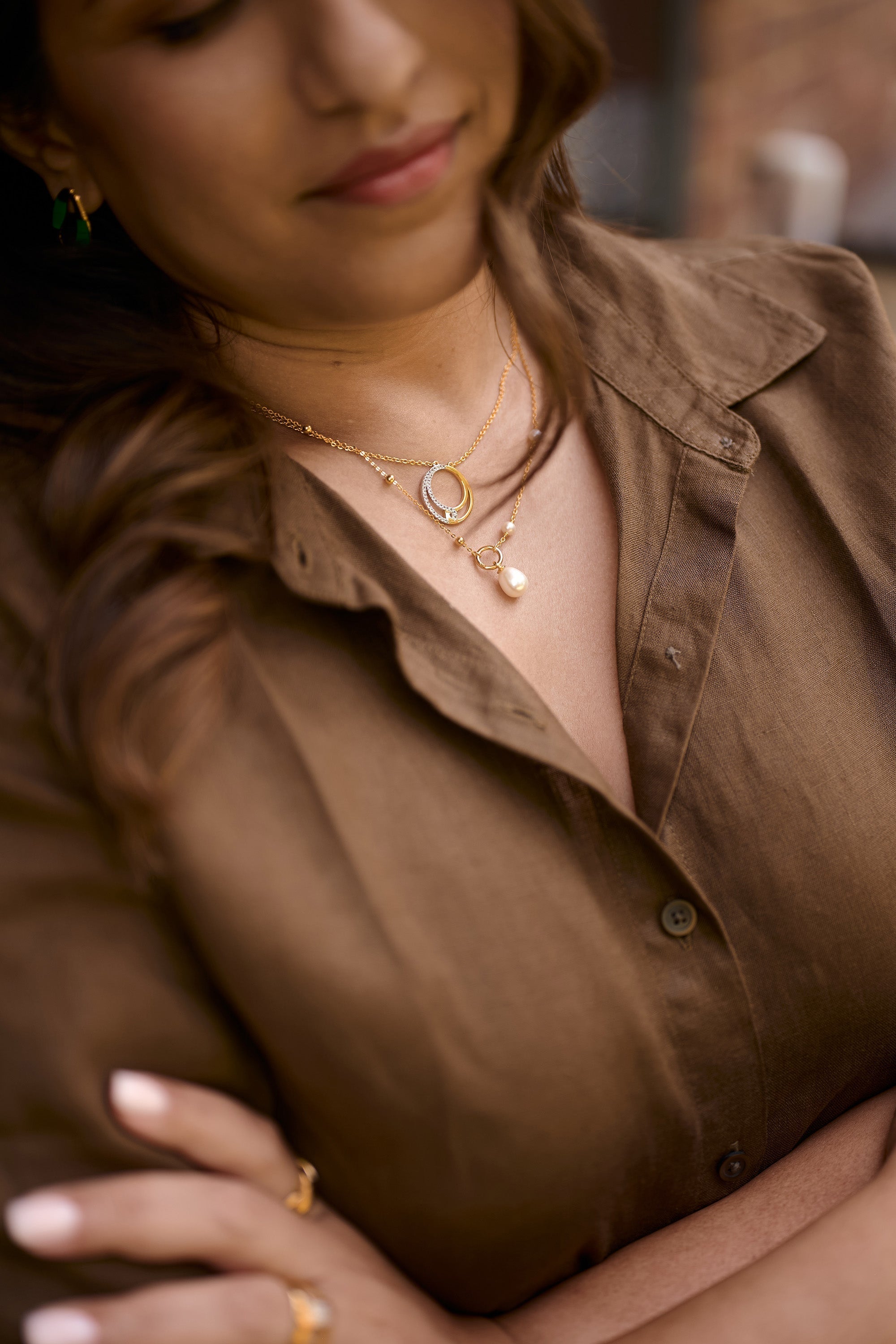 Close-up of woman wearing Argha Necklace with golden circle and pearl pendant