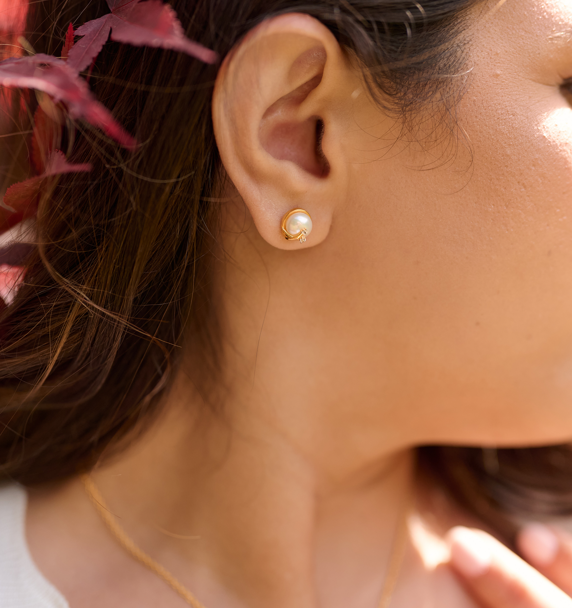 Close-up of ear wearing Poorna Earrings featuring a gold full moon and two angel stars design