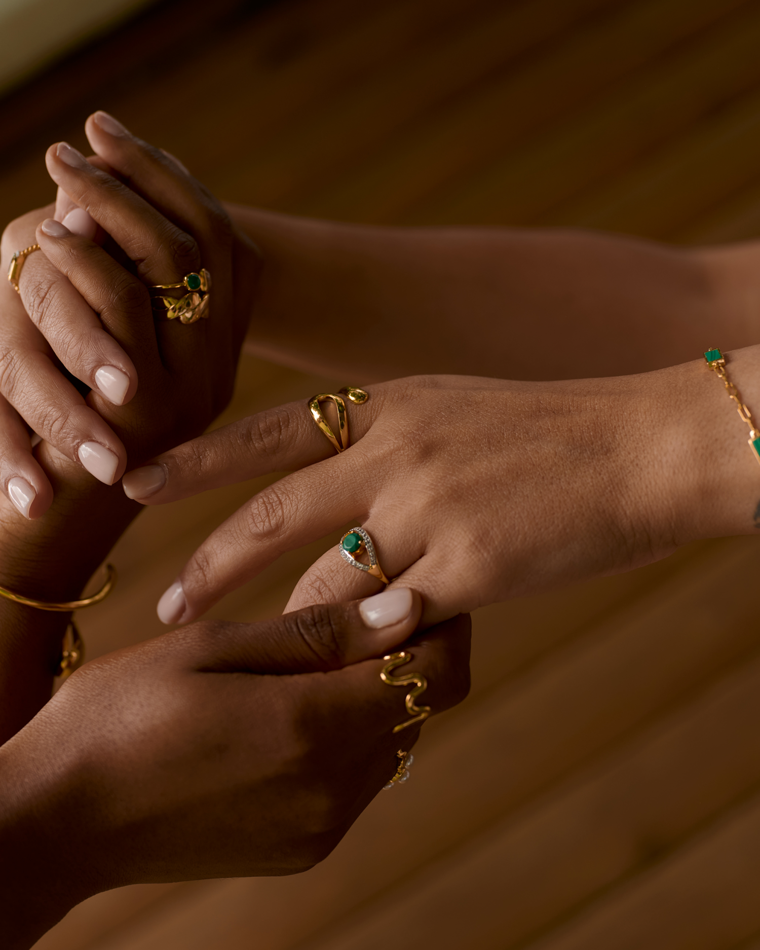 Saena Ring gold jewelry with green stone worn on hand showcasing elegant protective design