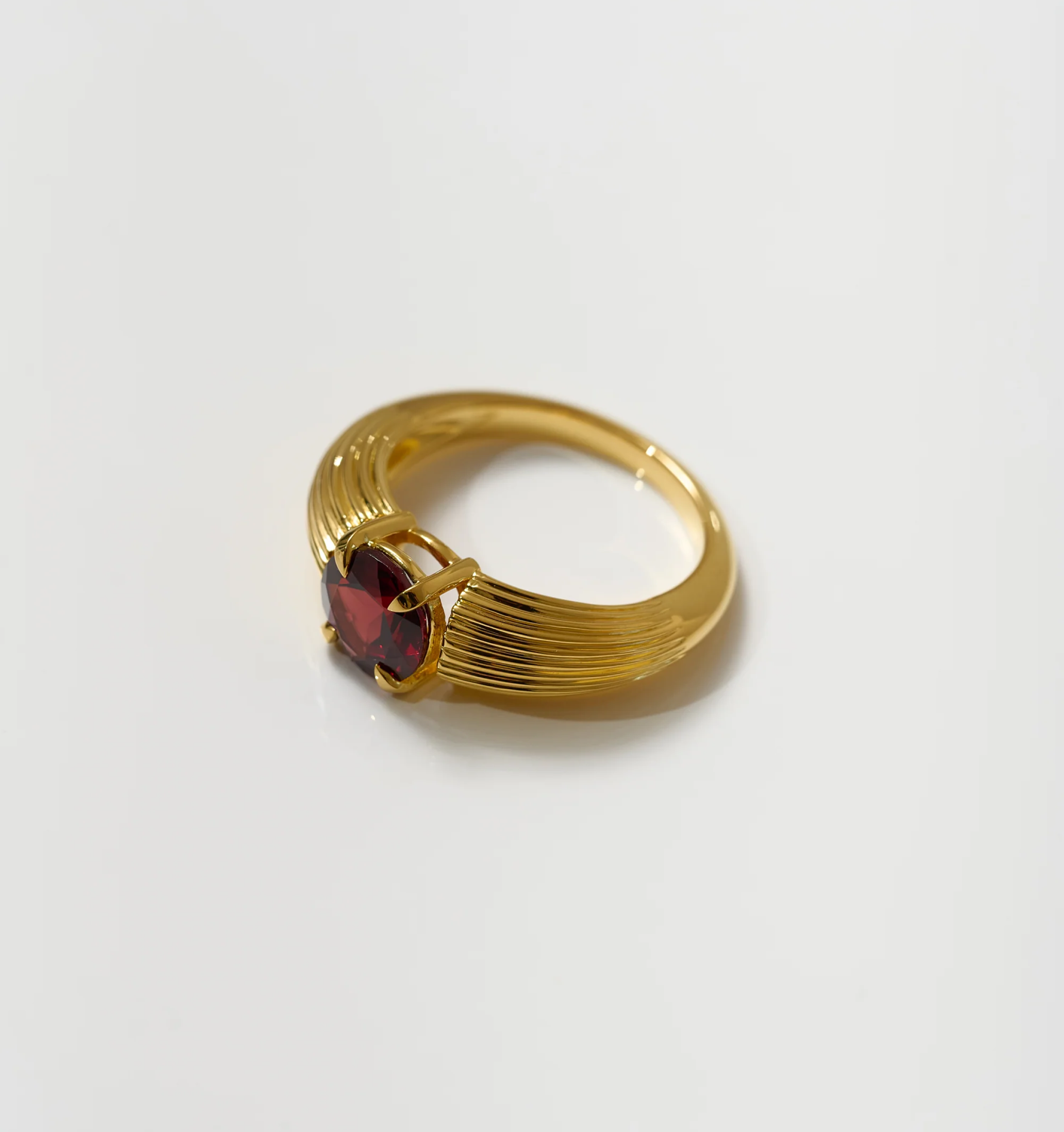 Ishaya Ring with deep red garnet set in bold gold band symbolizing fierce love and inner power