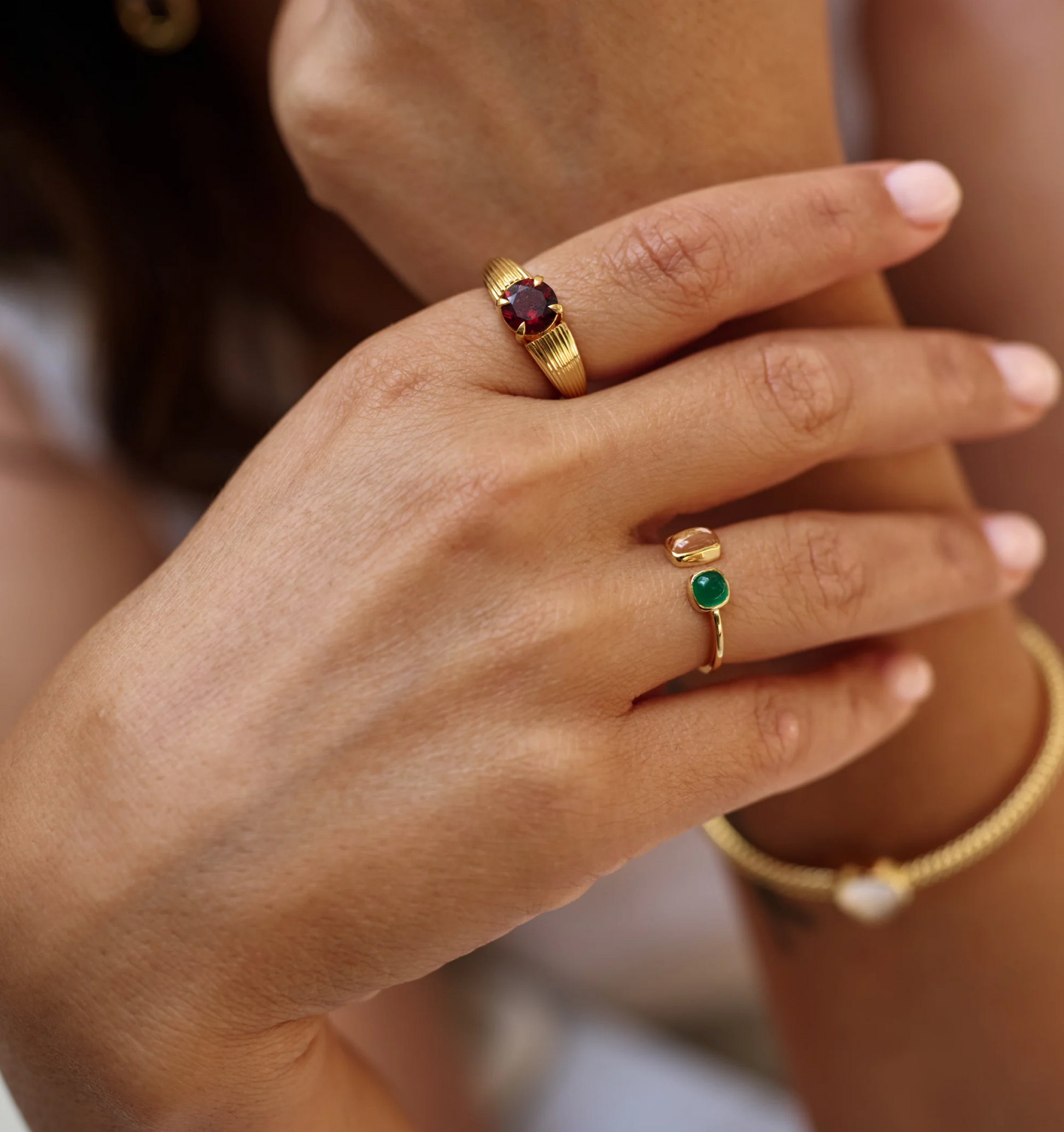 Ishaya Ring with deep red garnet set in bold gold on hand