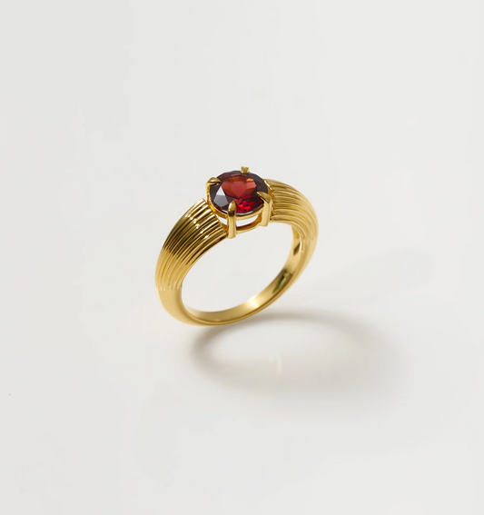 Ishaya Ring featuring deep red garnet set in bold gold band showcasing fierce love and inner power