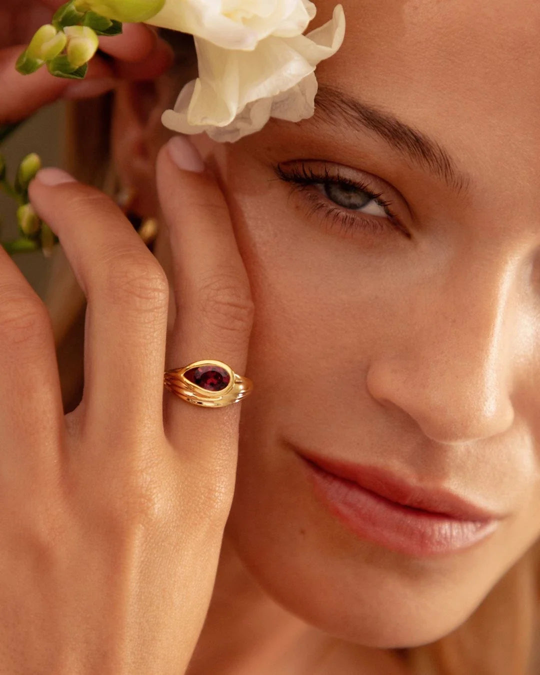 Korak Ring gold band with deep garnet bud design symbolizing potential before blooming
