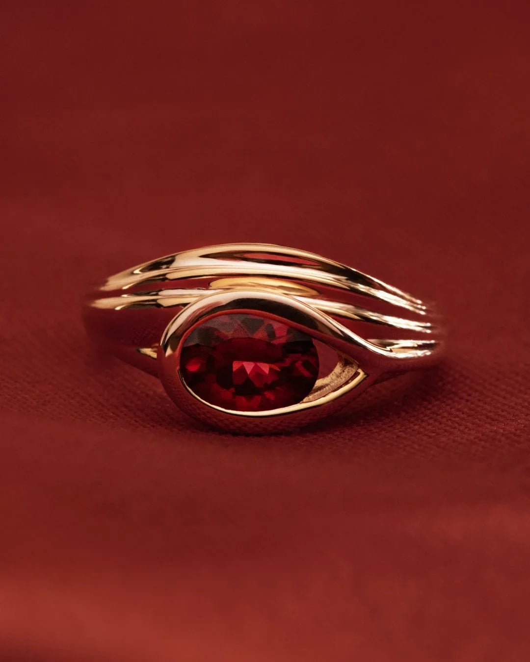 Korak Ring gold bud with deep garnet gemstone symbolizing potential before opening
