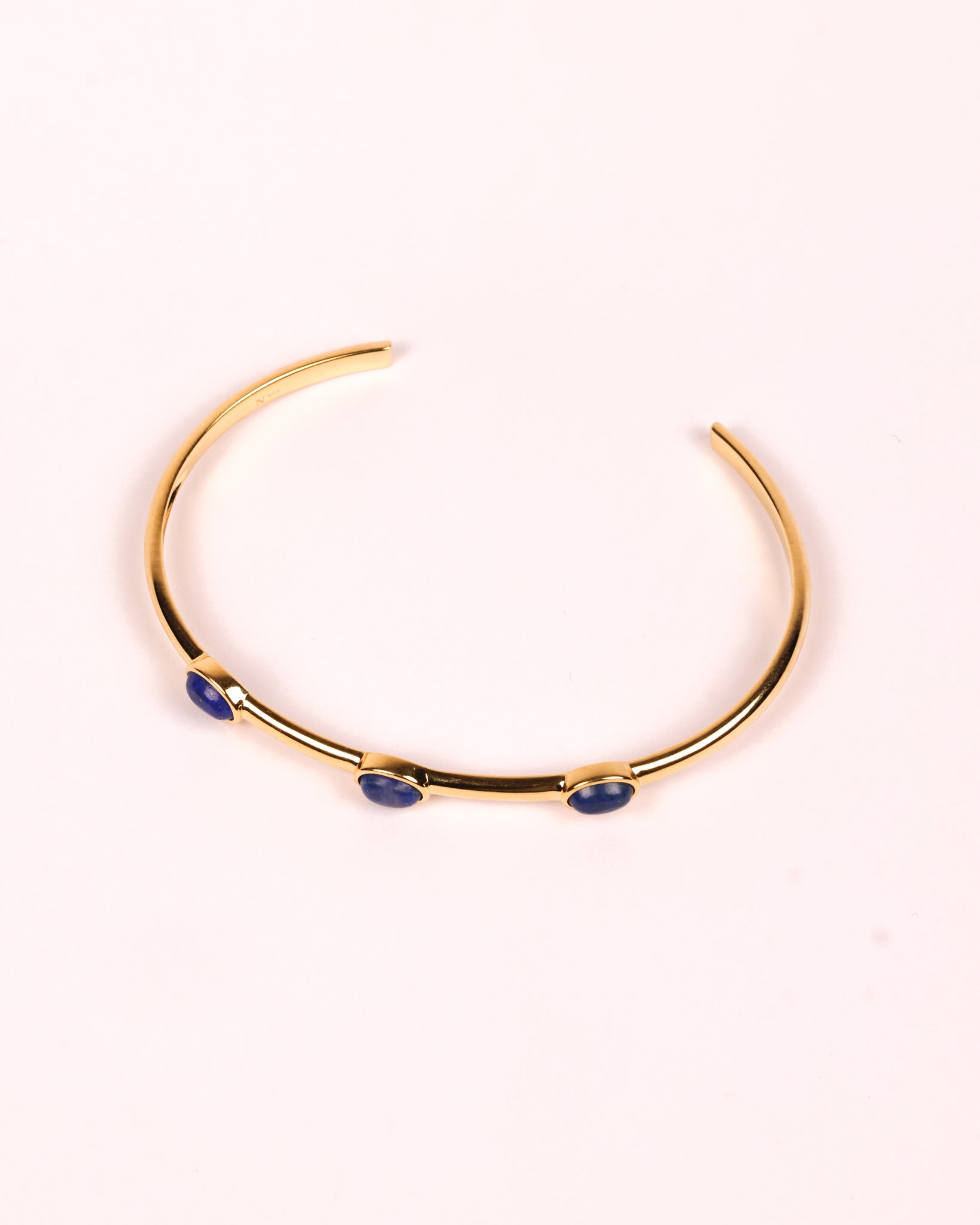 Trivena Cuff with three deep blue lapis lazuli oval cabochon stones in a minimalist gold setting.