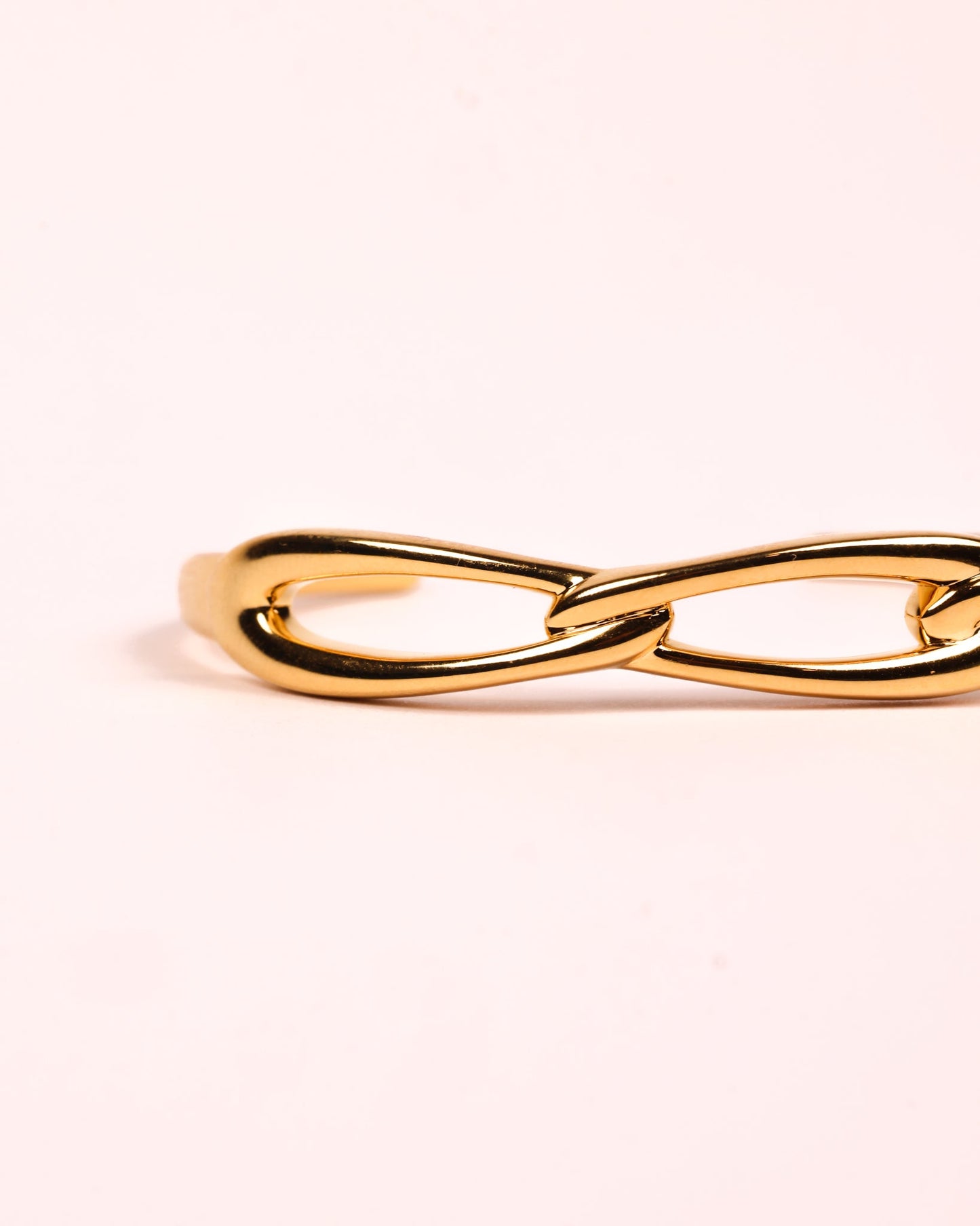 Sculptural gold Kadi Cuff with interlinked forms and open modern design.