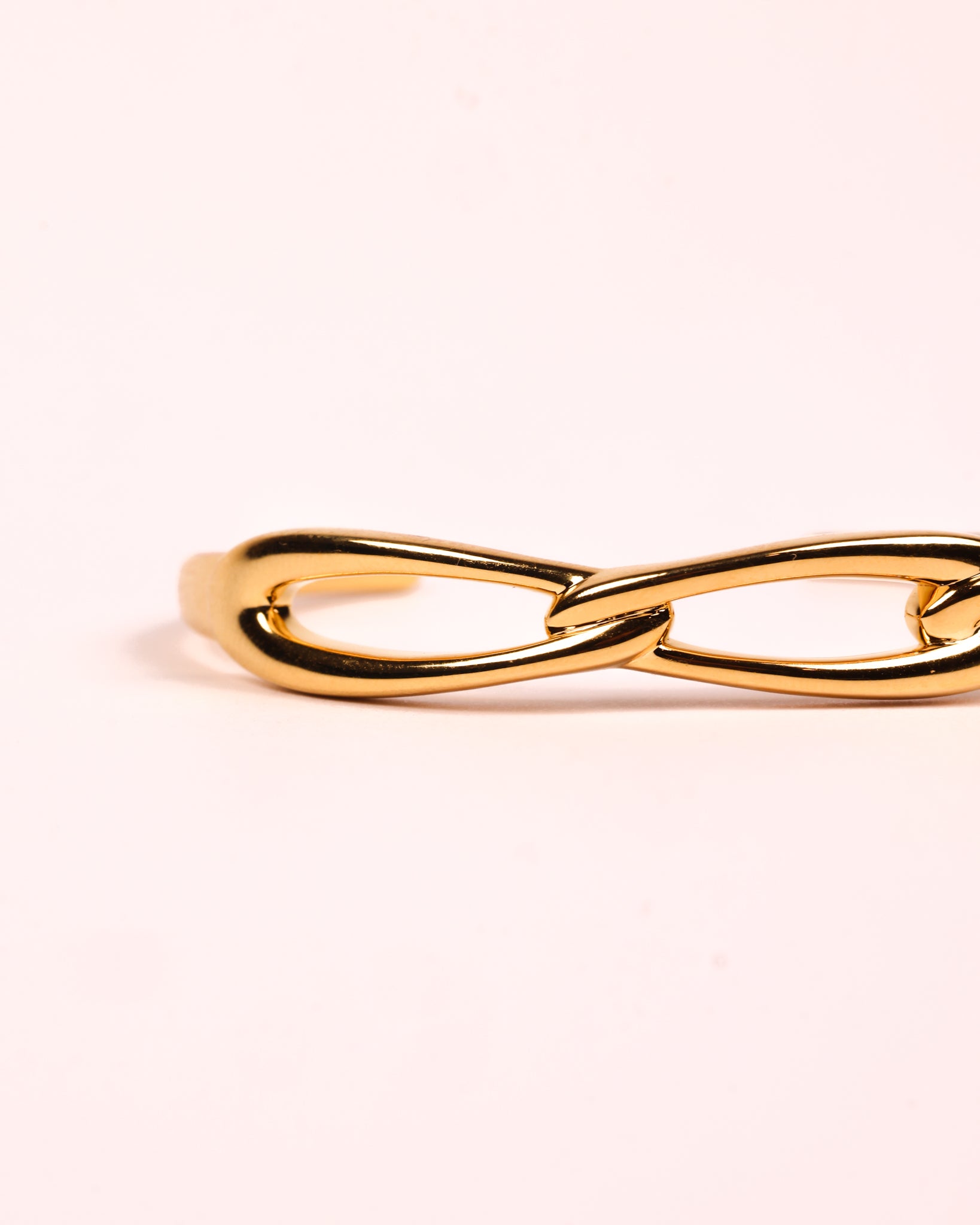 Sculptural gold Kadi Cuff with interlinked forms and open modern design.