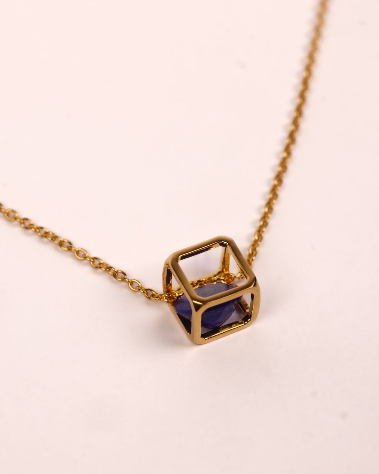 Kosha Necklace with round blue Lapis Lazuli stone in gold square frame showcasing modern geometric design