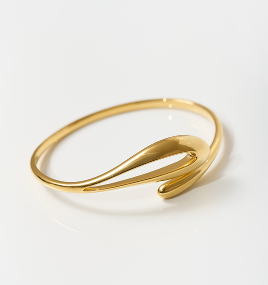 Elegant gold Oriya Cuff with fluid, sculptural spiral design on white background