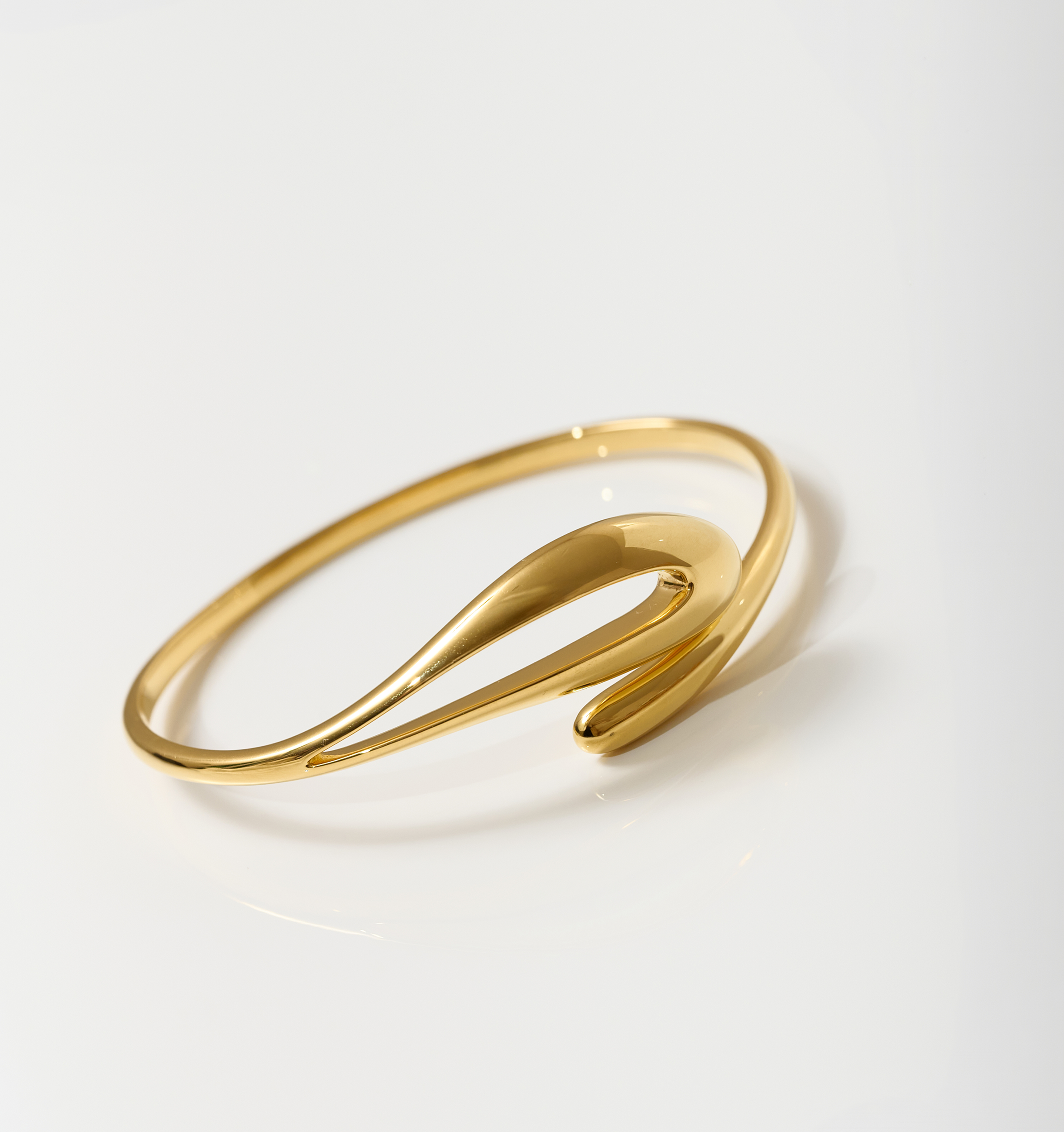 Elegant gold Oriya Cuff with a fluid, spiral design on a white background