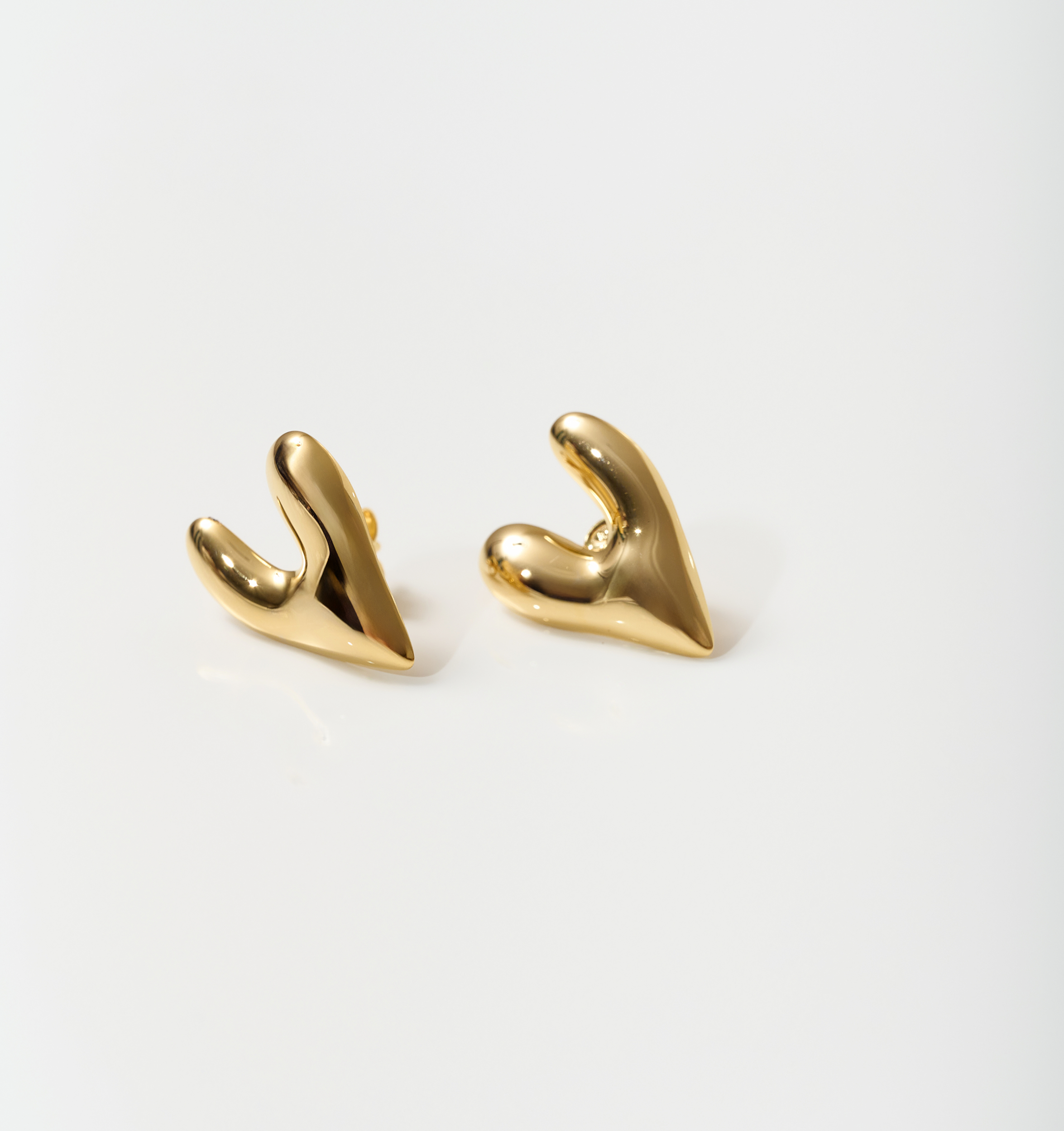 Gold-toned silver heart-shaped Avara Earrings with an uneven, sculptural, and raw organic finish