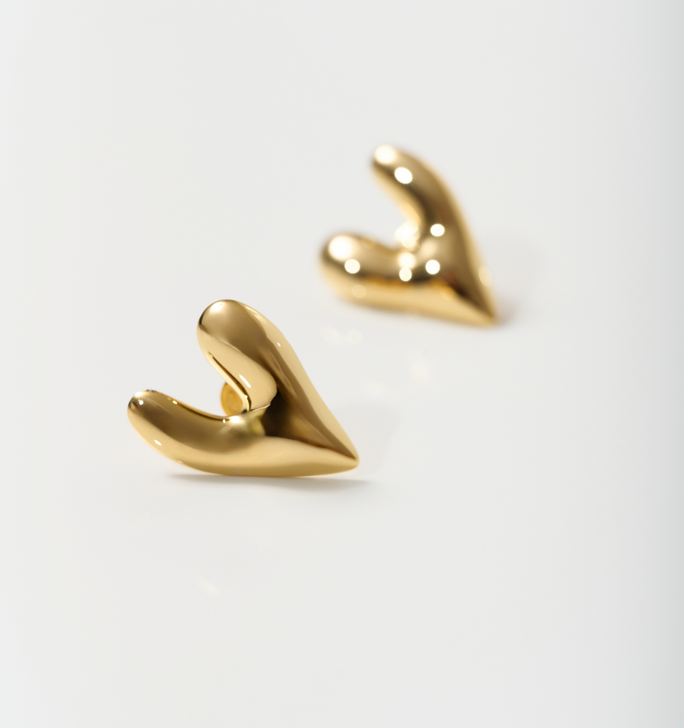 Gold-toned silver Avara Earrings with uneven, sculptural heart-shaped design and raw organic finish