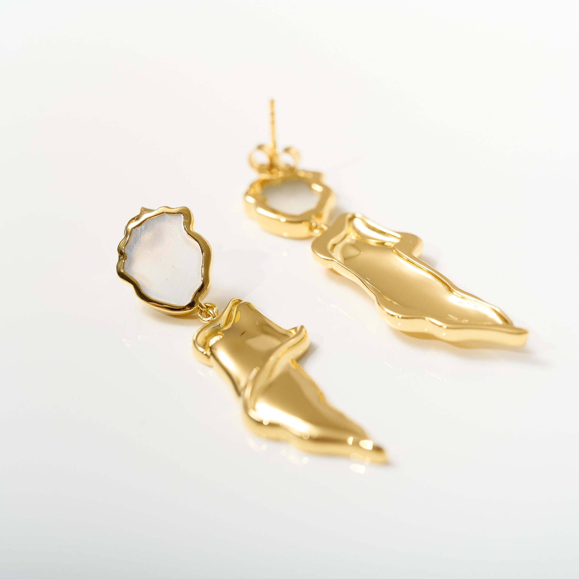 Thalena Earrings with gold sculpted design and moonstone accents on white background