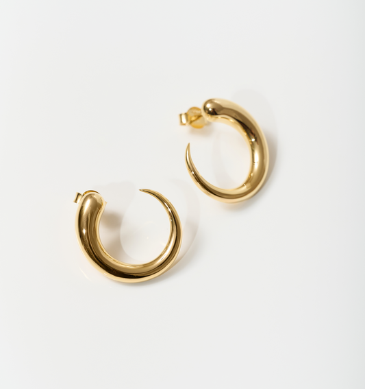 Minimalist gold Sora Earrings with a smooth, sculptural hoop design.