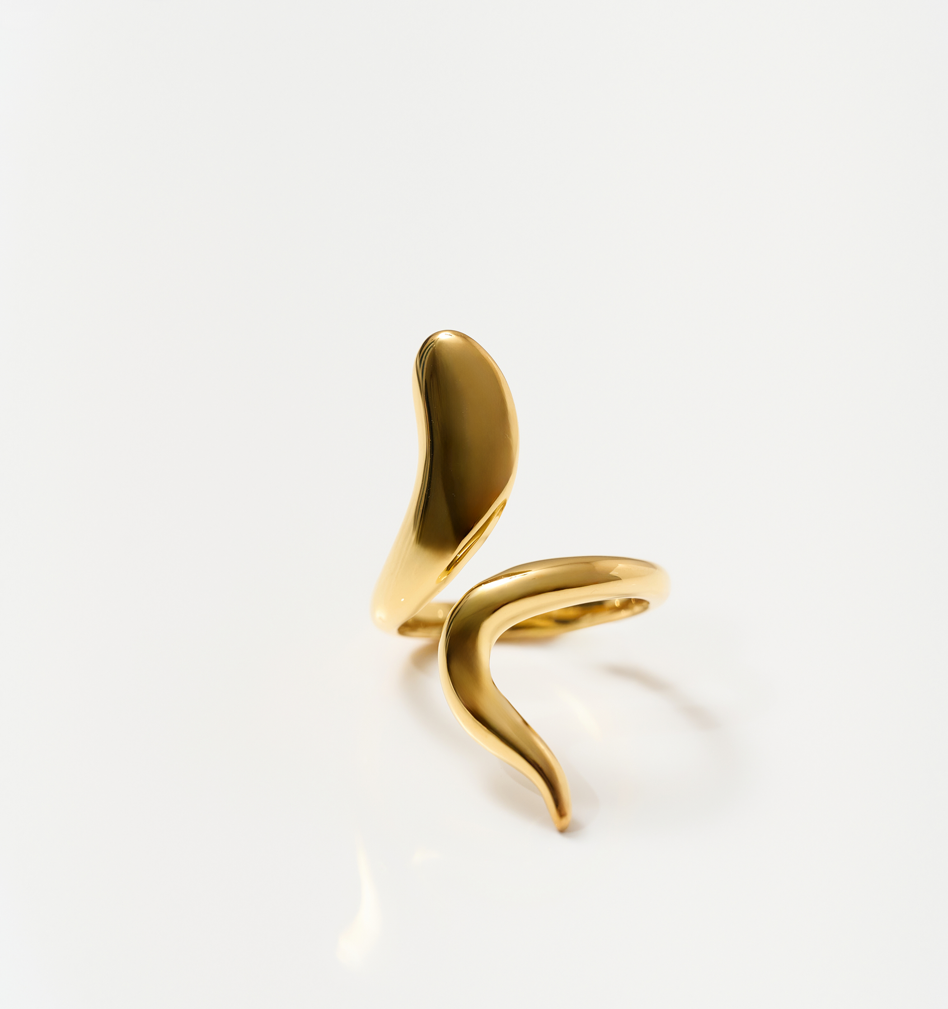 Minimalist luminous gold Saachi Ring with a bold, sweeping design symbolizing elegance and movement.