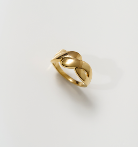 Niva Ring elegant gold band with fluid, intertwined design on white background