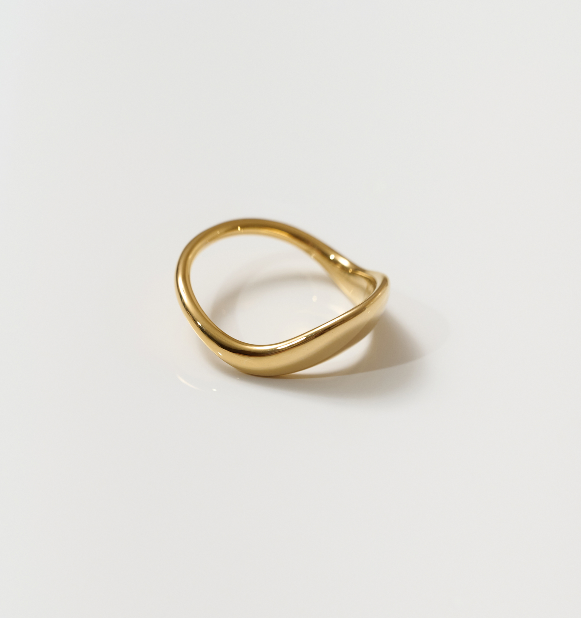 Alav Ring gold minimalist design with smooth curved shape on white background