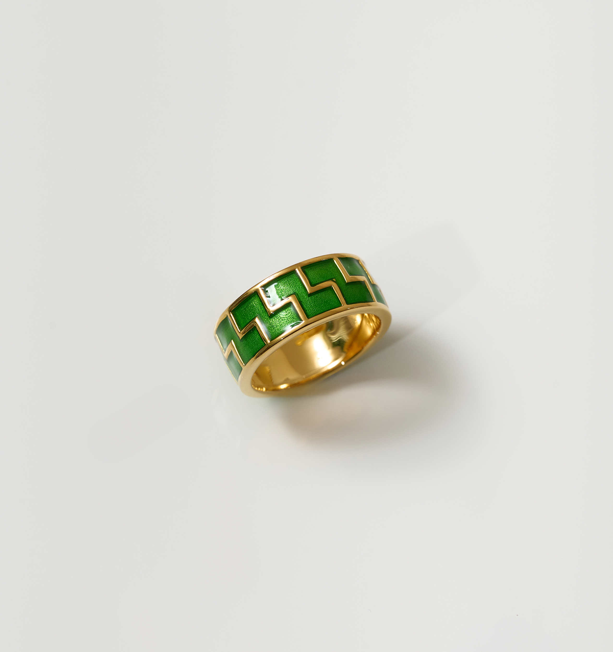 Arohi Ring gold band with green zigzag pattern on white background