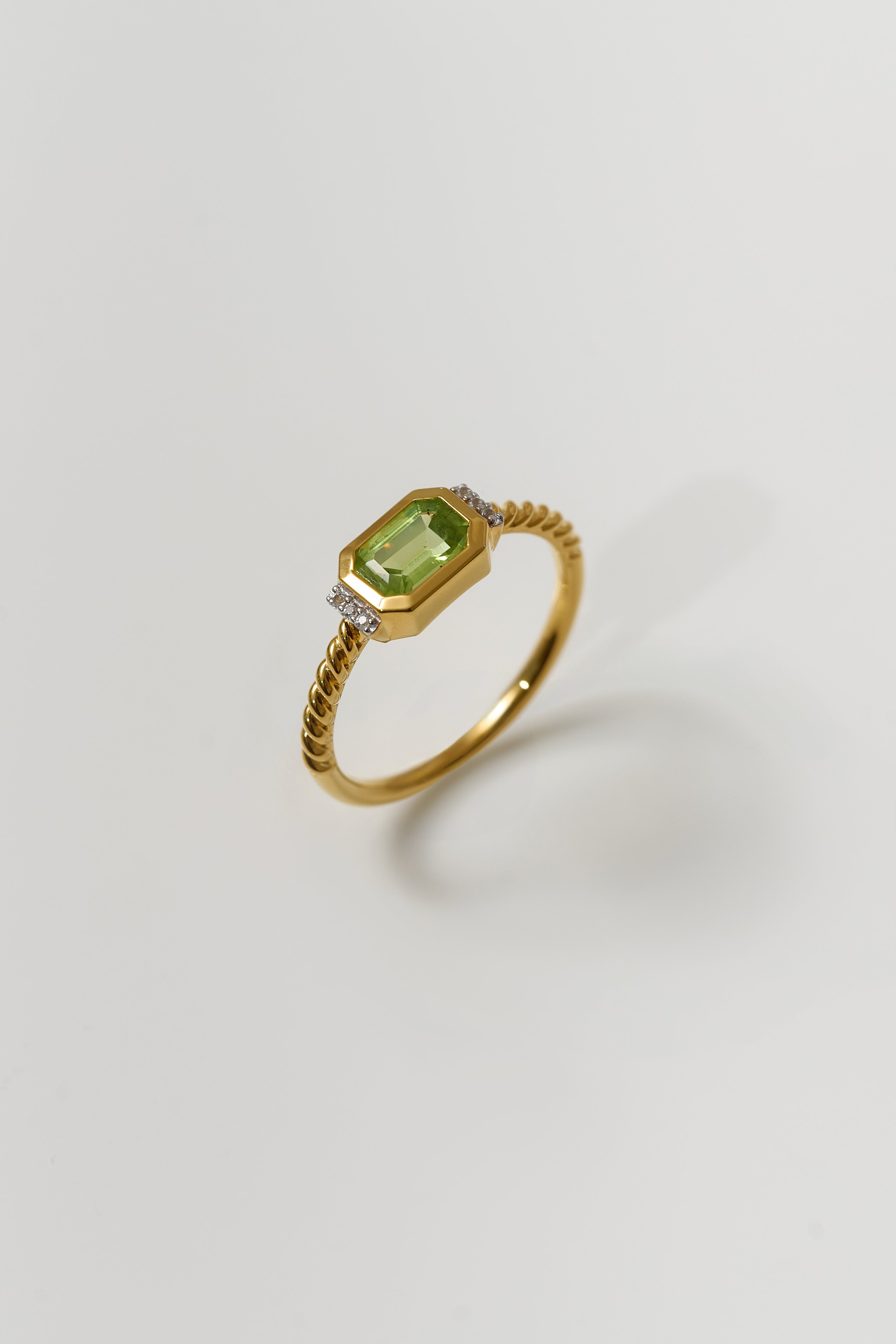 Gold Solae Ring with green peridot center stone and white topaz accents