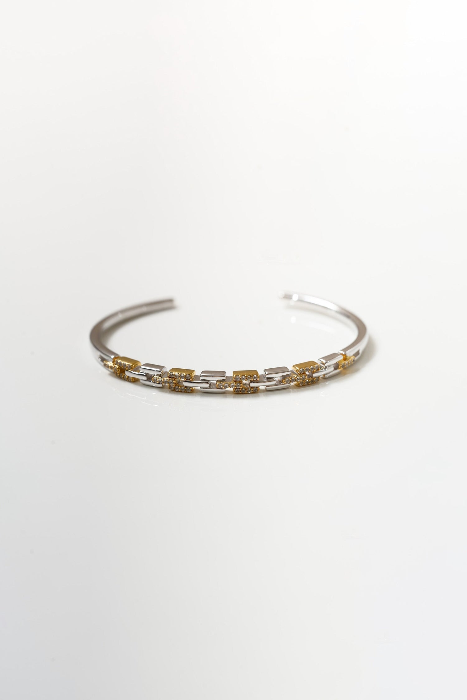 Elegant Noura Cuff bracelet with gold and silver links and sparkling stones.