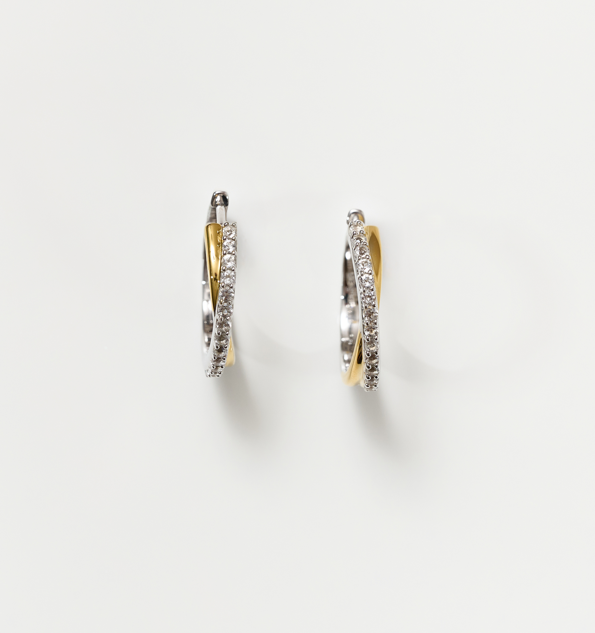 Mishri Hoops silver and gold cross earrings with white topaz detailing on white background