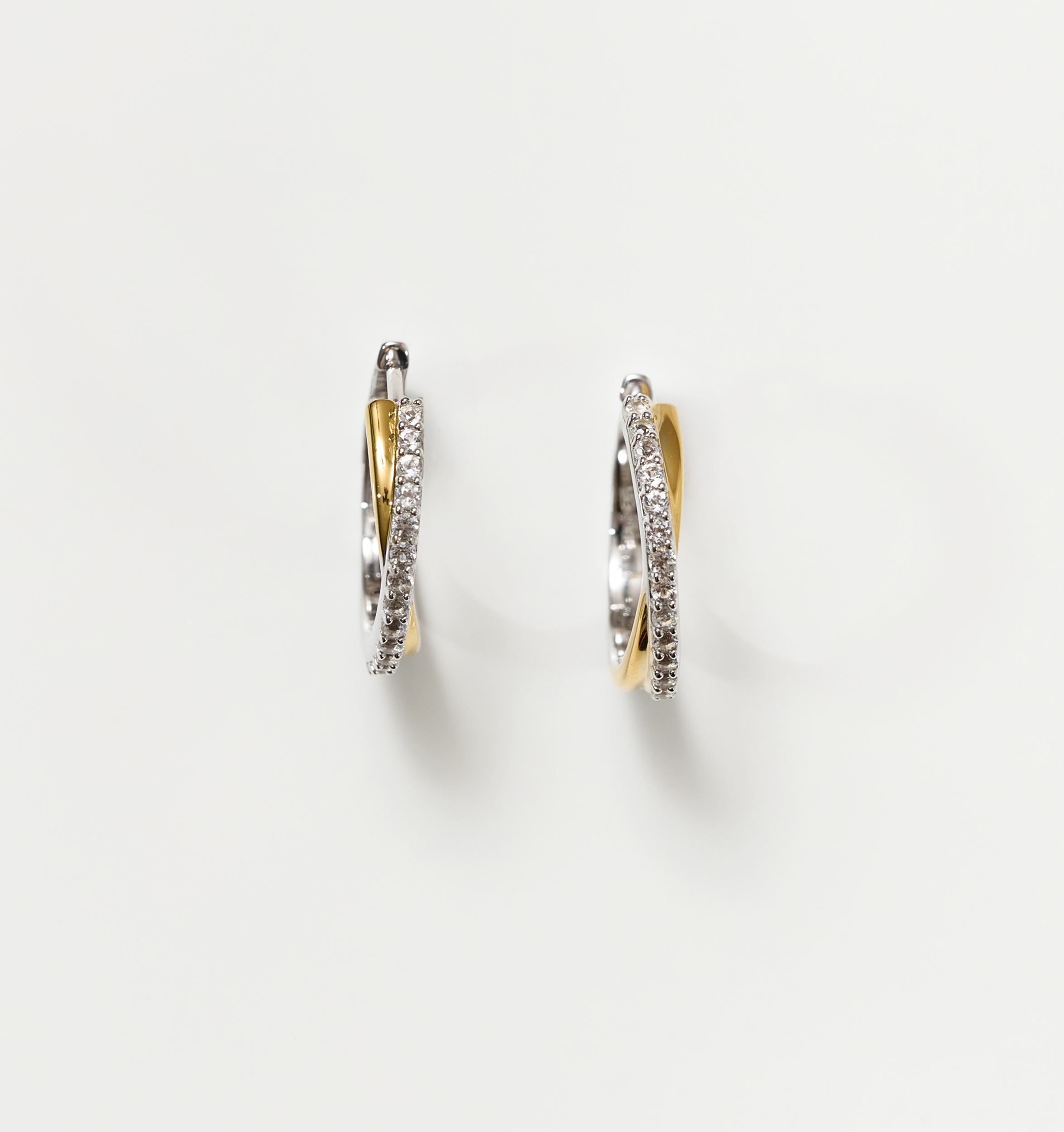 Mishri Hoops silver and gold cross earrings with white topaz detailing on white background