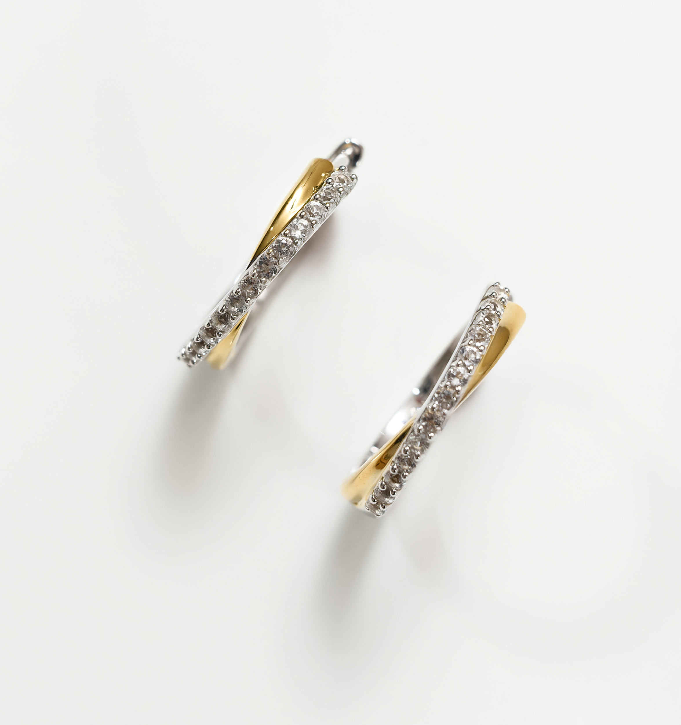 Mishri Hoops silver and gold earrings with white topaz crystals in a cross design