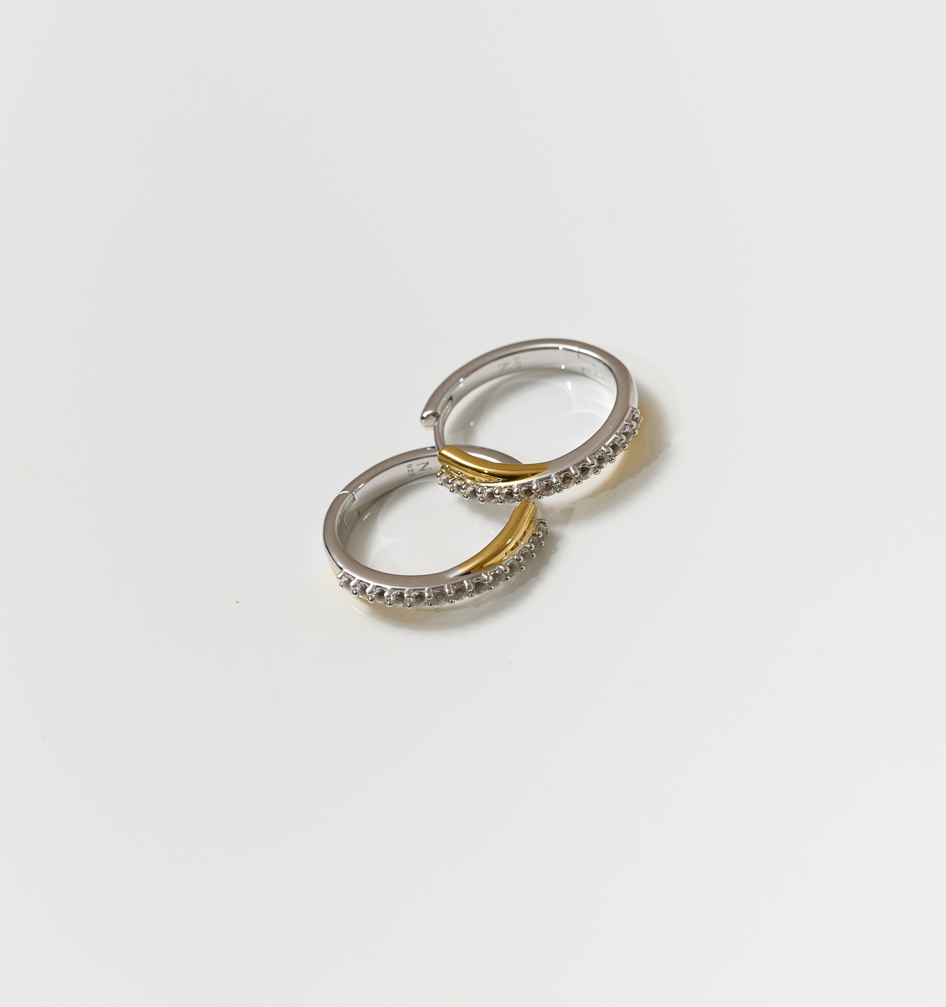 Silver and gold Mishri Hoops earrings with white topaz detailing on a white background