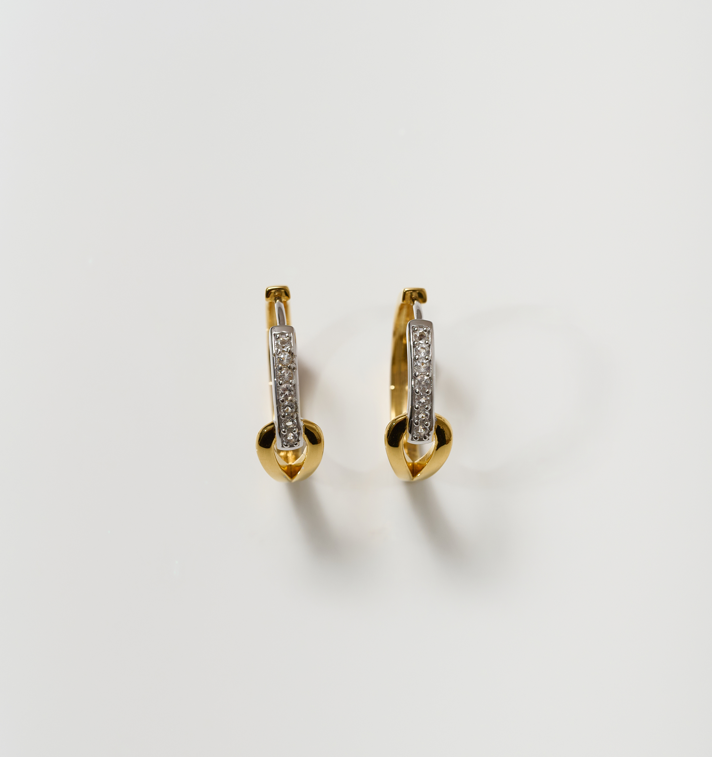 Ekatra Earrings featuring intertwined silver and gold with embedded stones on white background