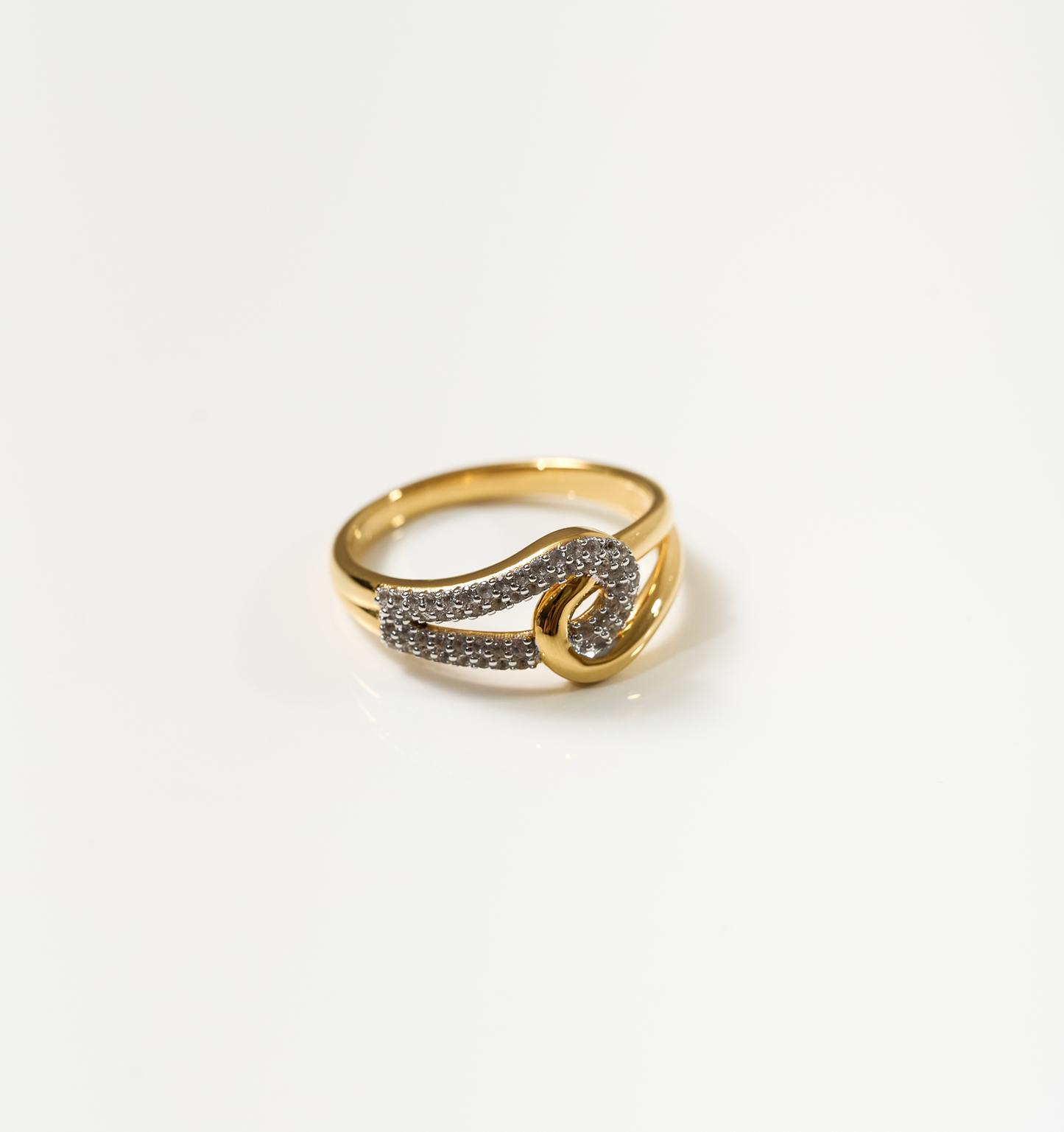 Sahaya Ring gold band with 55 white topazes forming an intertwined knot design