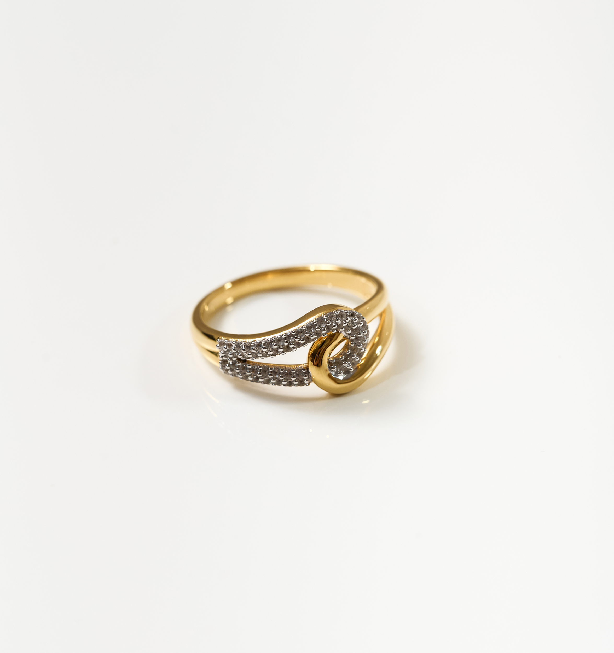 Sahaya Ring gold band with 55 white topazes forming an intertwined knot design